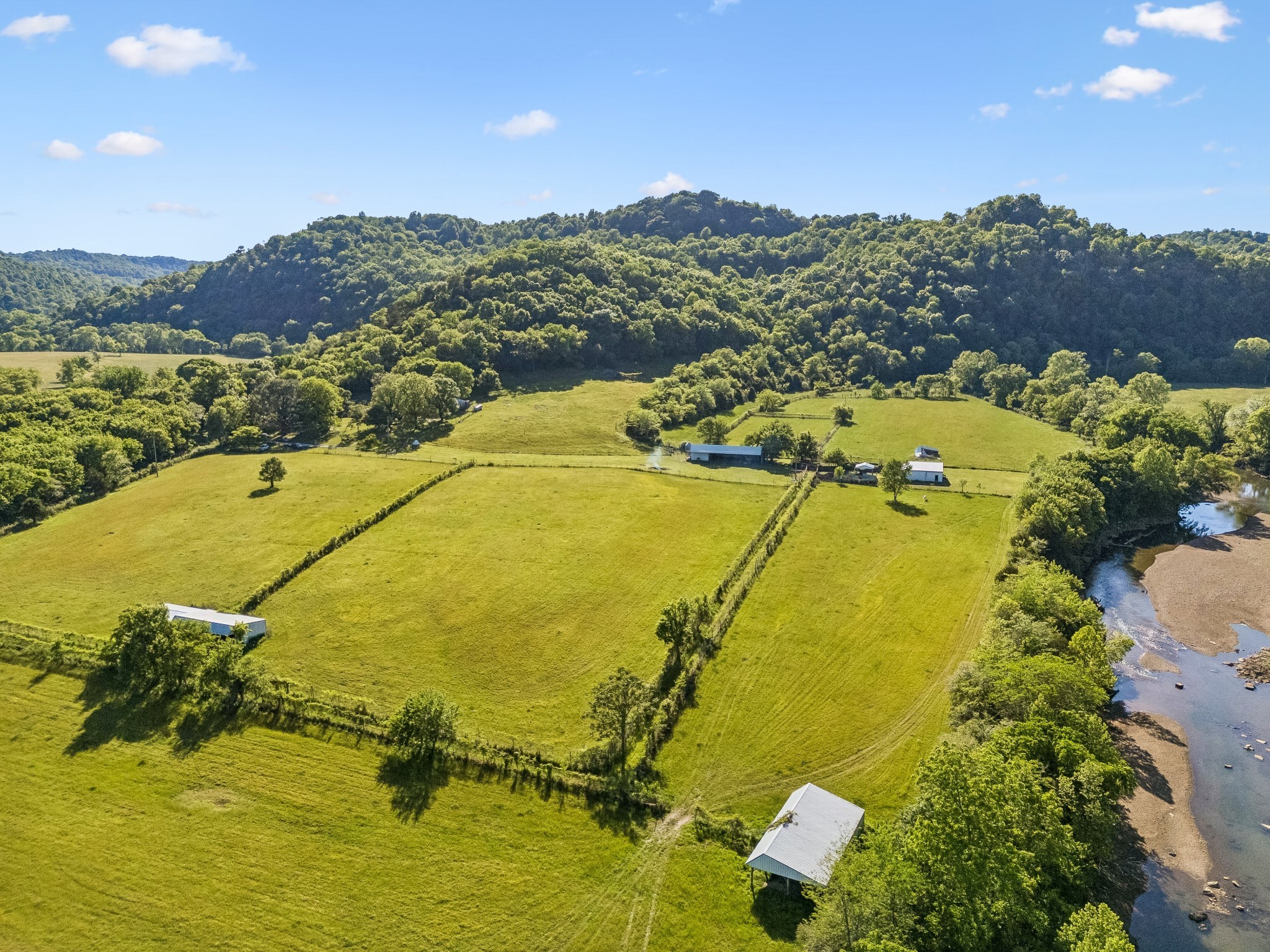 Once in a lifetime opportunity to own an exceptional tucked-away 62.82 acre creekside farm featuring approximately 3,000 feet of Smith Fork Creek frontage, over 20 acres of beautiful pasture land, and additional partially wooded acreage with excellent hunting opportunities. Straight out of “Little House on the Prairie,” this picturesque property offers rolling fields, mature trees, scenic creek views, and peaceful Tennessee countryside. The farmhouse is tucked beneath mature shade trees overlooking the creek and is serviced by a strong-producing well.Fenced and cross-fenced, the farm is ready for livestock, horses, or your dream mini farm operation. This unique property once housed exotic animals and still features portions of the high fencing. Farm improvements include a small pond, 2 barns, multiple loafing sheds, and a large 5-bay equipment shed with ample storage for tractors, hay, trailers, and equipment. Multiple water spigots are located throughout the farm, and electricity is already connected in several structures.Smith Fork Creek is well known for excellent smallmouth bass fishing and quickly feeds into the Caney Fork River with just a short float, offering endless recreational opportunities right from your property. Conveniently located only 6 miles from Center Hill Lake, boating and lake recreation are just minutes away. Whether you are searching for a working farm, horse property, hunting retreat, or peaceful country escape, this rare property offers endless possibilities with a setting that truly feels like stepping back into a simpler time. SEE VIDEO LINK