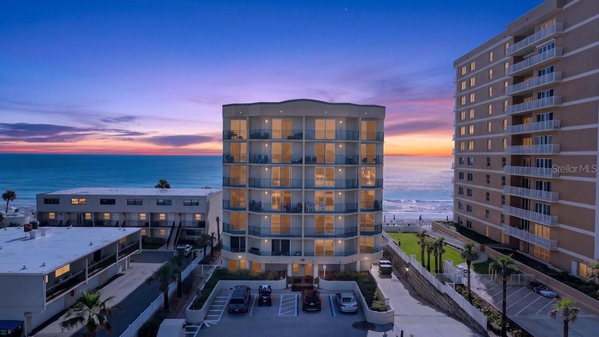 The first thing you'll notice is the light. It bounces off the water, pours through walls of glass, and fills the main living spaces with the shifting silver-blue of the Atlantic. You feel the ocean before you step onto the balcony. That's by design. Unit 202 arrived as a shell, and its owners built it out from nothing -- every wall, every line a deliberate choice. This is not one of many units in the same developer package. It's a custom, one-of-a-kind oceanfront home, shaped from the studs up, that exists nowhere else in DiMucci Tower. And the tower itself is rare: an intimate, seven-story boutique building where neighbors are few. For the buyer who has scrolled past dozens of look-alike high-rise listings, this is the one that stops you. Step through the entry and a welcoming foyer draws you in, framed by crown molding and a herringbone porcelain floor. To the left, an oversized laundry room delivers built-in cabinetry and generous storage.Move forward, and the home opens its heart: a chef inspired custom kitchen anchored by a spectacular 13-foot island wrapped in coastal shiplap. Gather friends here. Pour the wine here. Louvered white cabinetry and marine-grade hardware nod to the sea, while a walk-in pantry, built-in Thermador refrigerator, imported Italian range, and dedicated ice maker make everyday cooking a pleasure.To the right, a private guest wing tucks two spacious bedrooms and a full bath away from the main space -- quiet, separate, and full of playful coastal character.Then the home exhales. The dining area and living room unfold into one light-flooded expanse where the Atlantic commands the room. Custom bookshelves and shiplap millwork add warmth; glass frames the endless horizon. And here is what oceanfront buyers come searching for: the water is woven through daily life -- from the kitchen island, the dinner table, the sofa, and the primary suite where you wake.Slide open the glass doors and step onto a 30-foot oceanfront balcony that lives like a second living room. Below, the building's pool greets the sand; beyond, the beach stretches to the horizon. Cradle your morning coffee as the sun breaks the water. Let afternoons dissolve into the rhythm of the waves.Off the living room, the primary suite is a private waterfront retreat with its own balcony access, a spacious walk-in closet, and a beautifully designed en-suite with a large walk-in shower and custom storage. Throughout, porcelain tile, plantation shutters, custom millwork, and marine-grade accents carry a craftsmanship rarely found in condominium living.Constructed in 2019, DiMucci Tower is among the newest luxury oceanfront condominiums in Daytona Beach Shores -- and one of the most exclusive, with just seven floors. Residents enjoy direct beach access, an oceanfront pool and spa, a fitness center, a theater room, and a social clubroom, all overseen by a full-time, on-site HOA manager. The building is pet-friendly, and a two-week minimum short-term rental policy makes this an ideal income opportunity when the home isn't in use.Beyond the tower, miles of shoreline wait. Walk the sand at dawn. Whether you seek a full-time residence, a luxurious second home, or the retirement you've earned, Unit 202 offers what the market cannot replicate. Some homes you buy -- this one, you were always meant to wake up in.