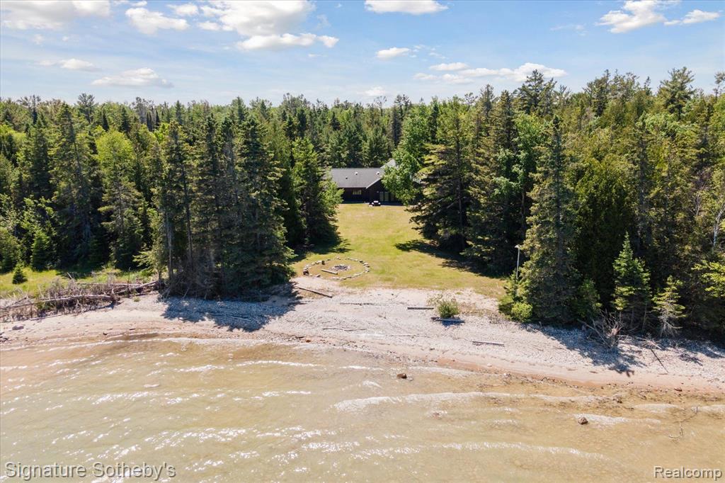 SUNUP LODGE, LLC. Few places in the world rival your own Lake Huron waterfront peninsula. With 710 acres, 3.5 miles of shoreline and 15 miles of drivable trails and roads. SUNUP Lodge is an ideal hunting retreat.  There has been over 30 years of cutting trees at different times, etc. to encourage growth to protect and offer breeding areas and grasses for Grouse and Whitetail Deer.  Come indulge in the beauty of a custom crafted hunting lodge in Alpena, MI. A rare opportunity exists for someone who wants seclusion & privacy that seamlessly blends functionality & artistry with a newer custom construction. An open layout made for entertaining, relaxing after a long cold day in the woods hunting, fishing or swimming/boating in Lake Huron.  A generous sized kitchen w/five gas burner stovetop & oven. Plus, an extra electric range oven conveniently located in the laundry rm.  Great Rm which spans the kitchen space & large enough to accommodate 100 people. The Great Rm has a custom crafted stone FP & a real tree log for the mantel. Gorgeous water view, when opening the French door from the front vestibule. Unique to this Lodge is the knotty pine paneling both on the walls & ceilings throughout. Floors are radiant heat thru out 5 BR’s & 3 full baths plus the essential pet shower conveniently located in the laundry rm.  Onsite includes a 40 x 40 metal pole barn, 1600 sq ft, which holds the essentials for maintaining this site w/a Kubota tractor, excavator, a 4 x 4, & other machinery. Solar panels, whole house 12K generator, 4 car carport for trailers, shed, propane & gasoline tanks, 15 hunting blinds, & a lovely patio w/log seating overlooking the water. Property is privately owned w/minimum usage each year & has been maintained by a professional maintenance person. All measurements are approx. Pre-qualified buyers & proof of funds required before appts are confirmed.  Parcel ID’s included in the sale: 01600100025100, 01403600000100, and 0160060004000.BATVAI