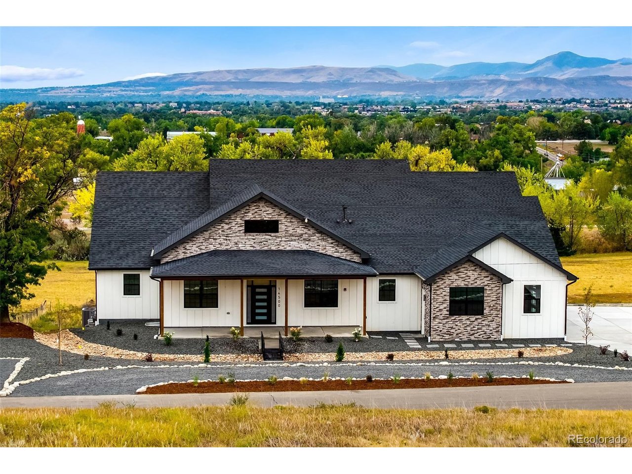 Welcome to 14500 W 82nd Ave in Arvada, an ultra-rare custom estate offering nearly 6,600 square feet of brand-new construction, sweeping city & mountain views, and a premier elevated 1-acre lot backing to 65 acres of open space at Pearce Park. This ranch with walkout basement showcases exceptional craftsmanship throughout with soaring ceilings, custom stonework, 2 modern fireplaces, iron railings, black-framed gridded windows, shiplap accents, custom shelving & hand-applied skip-trowel finishes. The chef's kitchen features ceiling-height custom cabinetry, soft-close hinges, dovetail drawers, glass accents, GE Cafe appliances, Level 5 granite countertops & wide-plank 8-inch white oak engineered hardwood flooring. The main level opens to a large composite deck with modern iron railings and incredible views. The luxurious primary suite captures mountain & city views and includes a spa-inspired bath with zero-entry steam shower, custom tile & frameless European glass. 2 additional main-level bedrooms each offer walk-in closets & en-suite baths, while an office, formal dining room with cabinetry & dual beverage fridges, and powder bath complete the level. The finished walkout basement is built for entertaining with a custom wet bar, island, full-size refrigerator, generous gathering spaces, 2 additional en-suite bedrooms, flex office/gym, powder bath & nearly 1,000 square feet of storage. Additional upgrades include 400 amp panel service to the home, extensive audio/video wiring, reverse osmosis water filtration & fire suppression systems. The nearly 1,500-square-foot side-load 6-car tandem garage offers 4 oversized individual bays with dual 220V power sources for EV charging or power tools, WiFi-enabled side-mount openers & abundant storage. The A-2 zoned lot allows up to 3 large domestic animals and offers 2 RV parking spaces, low-maintenance landscaping, expanded well, septic & leach field improvements, plus space for future outbuildings.