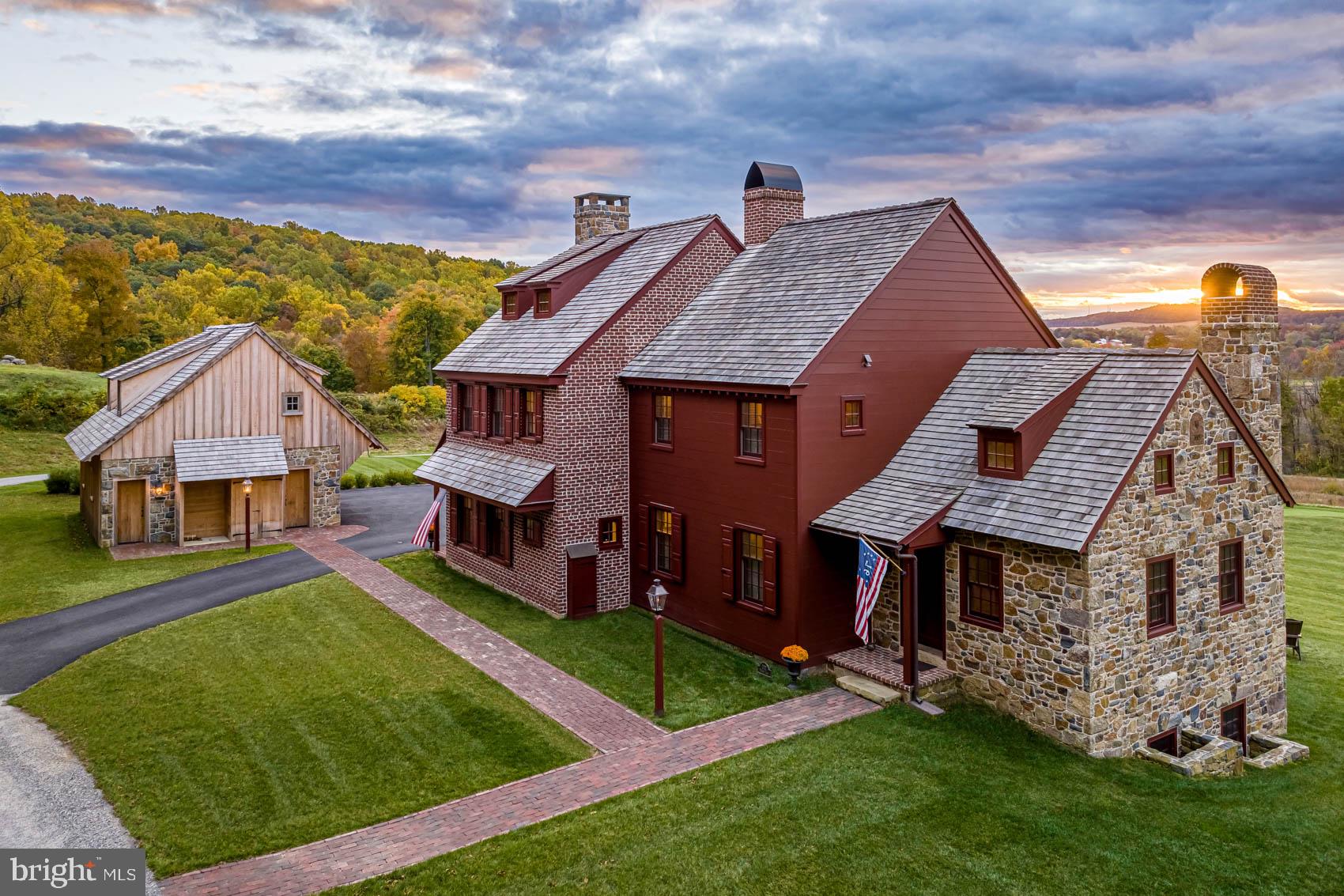 Crafted to feel as though it has always belonged to the landscape, this exceptional custom residence in Olde Bulltown Village, a distinctive collection of period-inspired residences, pairs the architectural character of historic Chester County with the comfort and ease of modern living.Set among the rolling hills of Northern Chester County, framed by the fairways of French Creek Golf Club and moments from Stonewall, the home was built in 2019 and thoughtfully expanded in 2022. It now offers approximately 4,000 square feet of finished living space with five bedrooms and five full baths across multiple levels. The addition was designed in the spirit of a historic Chester County home, drawing inspiration from the Betsy Ross House while incorporating the luxuries of a contemporary residence.Craftsmanship is found in details both subtle and significant. The original section features pine floors distressed on site and face-nailed with reproduction cut nails, while the addition showcases pin oak flooring milled from trees in Olde Bulltown. Custom cabinetry and hardware extend throughout, reclaimed post and beam from a historic local mill adds character between the kitchen and dining room, and real stone veneer and handmade kiln-fired brick reinforce the home's authentic period aesthetic.The kitchen is both beautiful and highly functional, centered around a handcrafted French Lacanche range with electric and gas ovens, honed soapstone countertops, custom cabinetry, and a generous butler's pantry, flowing naturally into the living and dining spaces for everyday living and effortless entertaining. Three fireplaces, each with gas or wood-burning flexibility, add warmth and character, including a distinctive Rumford fireplace with a reproduction 1700s fireback bearing a royal family seal.A private main-level office with its own closet and Jack-and-Jill bath offers an elegant work-from-home environment or flexibility for guests. Upstairs, the primary suite provides a peaceful retreat with a walk-in closet and natural-stone walk-in shower. Two additional generously sized bedrooms share a beautifully appointed hall bath with dual vanities, and a charming secret room beneath the staircase adds a playful and unexpected touch. The third floor offers a fourth bedroom or flexible office/studio with its own full bath, elevated views, and a generous walk-in storage room. The finished lower level includes a family room with fireplace, fifth bedroom, and full bath—ideal for guests, multigenerational living, or a private retreat.Outside, locally sourced blue-toned ironstone, shiplap and beaded siding, handmade oversized brick, cedar shingles, a reproduction metal chimney cap, and Bevolo gas lanterns continue the architectural detailing, while Andersen aluminum-clad windows provide modern performance. A stone patio and covered deck overlook rolling greens and protected open space, an exceptional backdrop for morning coffee, al fresco dining, sunset cocktails, and elegant entertaining. The detached two-car garage includes unfinished space above, already equipped with plumbing and electrical and positioned to capture fairway views—offering potential for a future office, studio, guest retreat, gym, or other personalized space.Perhaps the greatest luxury is the ease of ownership. The Olde Bulltown Village HOA provides lawn care, snow removal, and trash service, allowing residents to enjoy a custom Chester County home without the maintenance demands of a traditional estate.This is not a home designed simply to look old. It was crafted to feel established—to sit naturally within its surroundings and reflect Chester County's architectural heritage—while offering the quality and comfort of modern life, all within easy reach of West Chester, Philadelphia, the Main Line, and Amtrak. A rare combination of architectural authenticity, golf-course surroundings, protected landscape, sophisticated entertaining, and remarkably easy ownership.
