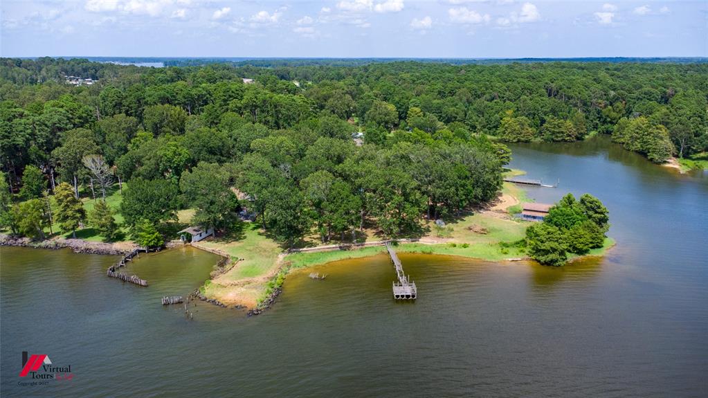 RARE TOLEDO BEND WATERFRONT OPPORTUNITY! Welcome to your own private waterfront retreat situated on approximately 1.75 acres comprised of two connected lots on one of Louisiana's premier fishing and recreational lakes. Positioned on a peninsula-like setting with water surrounding much of the property, this unique offering provides breathtaking views, incredible privacy, and endless possibilities.The property features an approximately 1,824 SF home with 3 bedrooms and 2 full bathrooms, ready for your personal updates and vision. Whether you're looking to renovate, build your dream lake home, create the ultimate family retreat, or develop a highly desirable vacation rental, this property offers the location and acreage to make it happen.Outdoor enthusiasts will appreciate the three private docks, expansive shoreline, mature shade trees, and room to enjoy everything Toledo Bend has to offer. Bring your boats, jet skis, and fishing gear; this is truly a fisherman's paradise.Additional improvements include a large detached workshop and garage, providing ample space for boats, ATVs, equipment, hobbies, or storage.Properties offering this much waterfront acreage, multiple lots, and three docks rarely become available. A true Gem, this represents an exceptional opportunity to own one of the area's most unique waterfront properties.Don't miss your chance to create something truly special on Toledo Bend!