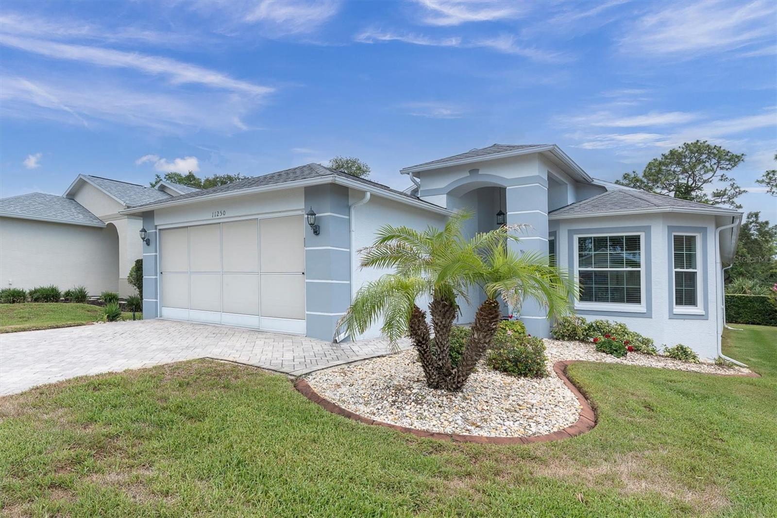 Virtually Staged. Welcome to this exquisitely maintained home located within the highly sought-after 55+ gated golf community of Heritage Pines, where elegant living and resort-style amenities create an exceptional Florida lifestyle. Impeccably cared for and thoughtfully updated throughout, this very light and bright residence offers a spacious open-concept design enhanced by abundant natural light, wood laminate flooring throughout the main living areas, and Italian porcelain tile in the kitchen, bathrooms, laundry room, and hallways, with no carpet anywhere in the home.From the moment you enter the inviting foyer, the home’s pristine condition and attention to detail are immediately apparent. The beautifully designed kitchen features Corian countertops, wood cabinetry, newer appliances including the stove, microwave with exterior venting, and refrigerator, along with a charming breakfast nook for casual dining. The kitchen flows effortlessly into the formal dining area and expansive family room, creating an ideal setting for both entertaining and everyday living.A standout feature of the home is the stunning enclosed lanai, offering additional heated and air-conditioned living space. Surrounded by oversized windows with window treatments and finished with laminate flooring, this elegant retreat provides the perfect place to relax and enjoy the peaceful surroundings year-round.The luxurious primary suite offers two walk-in closets and a spacious ensuite bath complete with dual sinks, oversized vanity, large walk-in shower, and ADA-height commode. The guest bedroom provides comfortable accommodations for family and visitors, while the beautifully renovated guest bathroom was updated in 2020 and showcases a large walk-in shower, quartz vanity, and ADA-height commode.Additional features include an inside laundry room with washer and dryer included, garage storage shelving, attic storage space, ceiling fans in all rooms, and an extensive list of valuable upgrades already completed for the next owner’s peace of mind. Improvements include a NEW ROOF (2019), exterior paint (2025), whole-house GENERAC generator, NEW WINDOWS, hot water heater, enclosed lanai, upgraded 12” ductwork throughout the home, gutters, brick pavers, landscape curbing, recessed kitchen lighting, solar tube for enhanced natural light, surge protection inside and out. This exceptionally well-maintained property reflects true pride of ownership, with many recent updates already completed — see attached upgrade list for full details.The HOA provides outstanding convenience by maintaining the exterior of the home, including lawn care, irrigation, pest control, hedge and tree trimming, and exterior painting.Residents of Heritage Pines enjoy access to premier amenities including an 18-hole golf course, clubhouse with restaurant and bar, resort-style pool, tennis courts, pickleball, bocce ball, performing arts center, woodworking shop, and an active social calendar filled with daily activities and events. This golf-cart-friendly community also features beautifully maintained sidewalks and street lighting throughout.Experience refined Florida living in the exceptional community of Heritage Pines, Country Green Village.