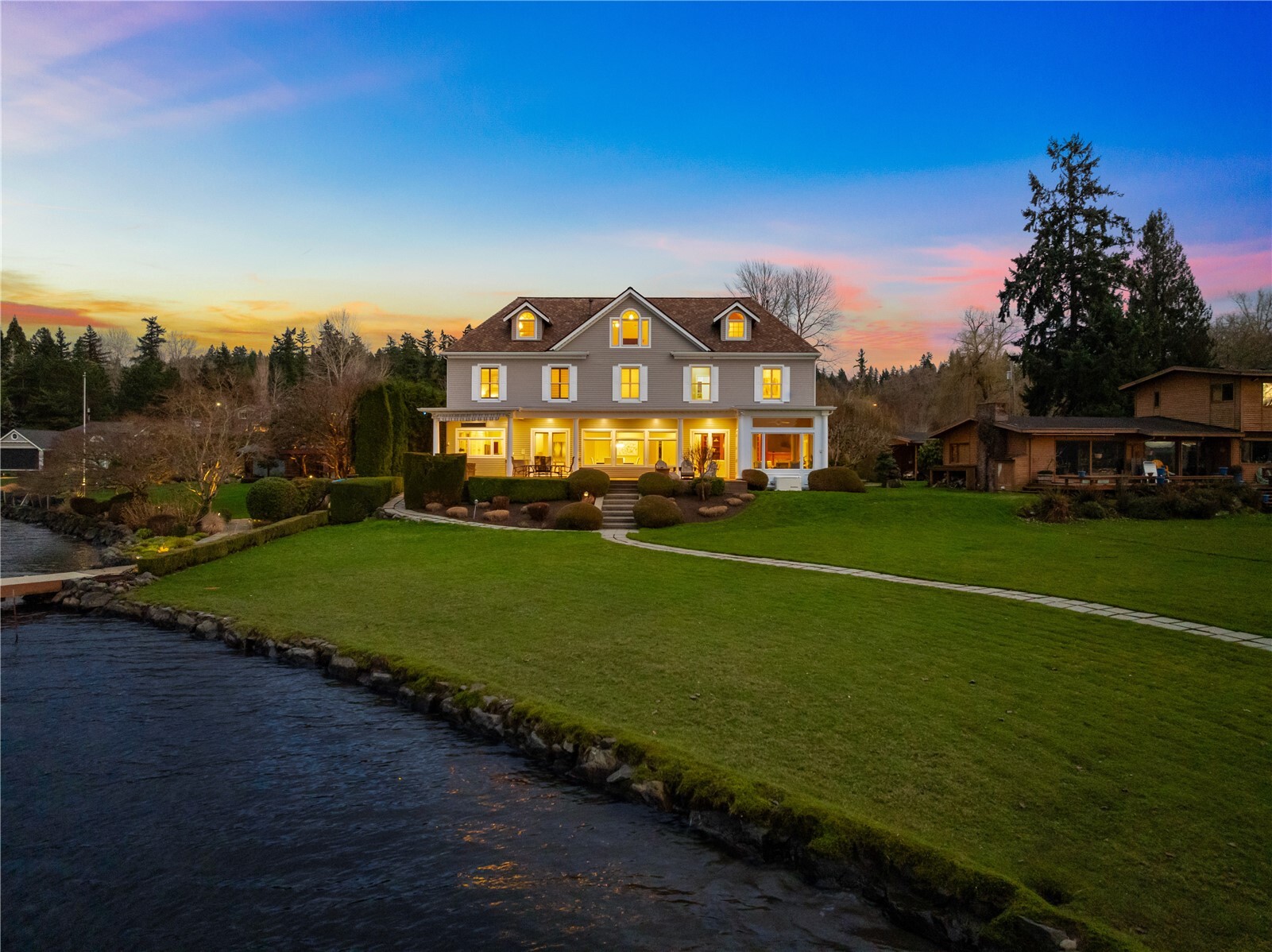 Set along 160’ of sparkling shoreline and spanning over half an acre, this extraordinary waterfront estate offers a rare opportunity to experience one of Lake Sammamish’s most captivating settings. Morning light dances across the water, while brilliant western sunsets bathe the lake in gold as eagles soar overhead. Expansive walls of glass invite natural light throughout, creating an effortless connection to the surrounding landscape. French doors open to a generous lakeside deck with hot tub, perfect for dining outdoors as boats drift by and evenings linger above the shore. Inside, rich oak hardwoods and a welcoming fireplace ground the great room, while the chef’s kitchen with oversized island inspires memorable gatherings. A sun-drenched sunroom frames ever-changing lake views throughout the day. Vaulted ceilings and exposed beams define a spectacular bonus retreat with kitchenette and theatre, setting the scene for cinematic movie nights on a grand scale. Retreat to the tranquil primary suite, where a private fireplace and spa-inspired bath offer a peaceful escape as twilight settles over the lake. With a private dock, boat and jet-ski lifts, two dedicated offices and a four-car garage, this exceptional estate invites you to embrace a lifestyle shaped by the beauty and rhythm of the water.