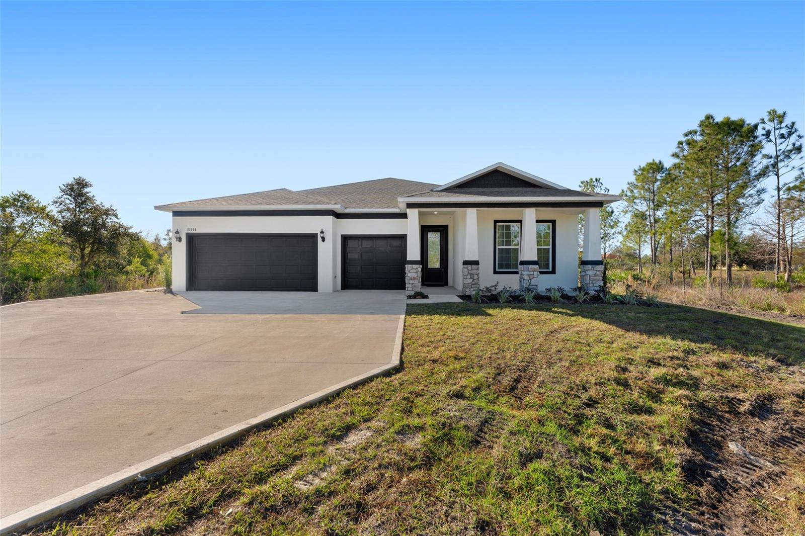 Welcome to your dream home in Wedgefield, where modern luxury meets peaceful country living. Situated on a full acre surrounded by mature trees, this elegant new construction residence offers the perfect blend of space, privacy, and thoughtful design.Step inside to high tray ceilings, custom flooring, and upscale finishes that set the tone from the moment you enter the open foyer. The split-bedroom floor plan provides both comfort and functionality, with two spacious guest bedrooms located at the front of the home and connected by a convenient Jack-and-Jill bathroom.The heart of the home is the expansive open living area, where the living room, dining space, kitchen, and breakfast nook flow seamlessly together. The designer kitchen is a showstopper, featuring custom cabinetry, stone countertops, and beautiful tile throughout—perfect for everyday living and entertaining alike.Tucked away at the back of the home for maximum privacy, the primary suite offers a quiet retreat with plenty of space to unwind. A standout feature of this home is the private-entry fourth bedroom suite, complete with an additional flex room equipped with a kitchenette (sink and countertop). This versatile space is ideal for multigenerational living, long-term guests, or a private home office setup.Additional highlights include a large laundry room, a 3-car garage, and the peace of mind that comes with brand-new construction. Step outside to enjoy the covered lanai and an extended paver patio—perfect for entertaining or relaxing while taking in the serene, tree-lined surroundings.Located in the desirable Wedgefield/Rocket City area of East Orlando, this property offers the feel of country living while remaining close to everything. Enjoy shopping and dining at Waterford Lakes Town Center (about 20 minutes away), explore nature at Hal Scott Preserve (under 10 minutes), or head to Cocoa Beach (approximately 35 minutes) for a day by the ocean. You’ll also appreciate convenient access to Lake Nona’s Medical City, UCF, Orlando International Airport, and major highways including SR-528 and SR-520.If you’ve been searching for room to breathe without giving up city convenience, this exceptional home delivers it all. Whether you're looking for your forever home or a private retreat with flexibility, this is a must-see opportunity.