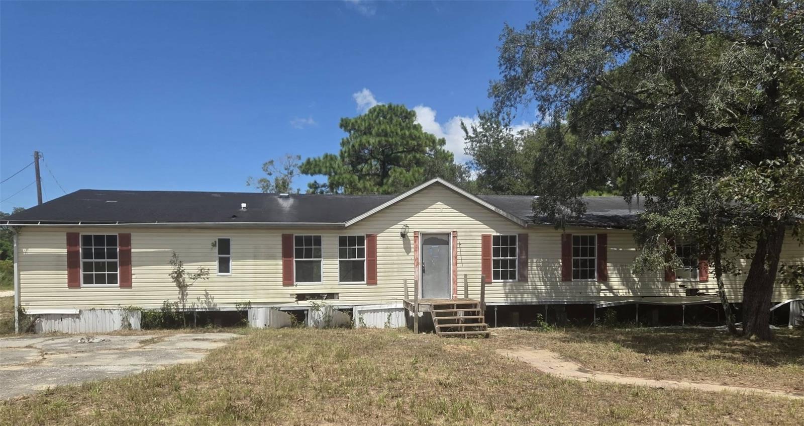 Experience peaceful country living without sacrificing convenience! Situated on a 1.44 acre agricultural corner lot in Hudson, this property offers endless possibilities for your dream homestead—bring your horses, chickens, and vision! Located in a desirable No-Flood Zone with electric, well and septic, this fixer-upper is a prime canvas for investors or buyers looking to build equity. Selling strictly AS-IS, cash-only.