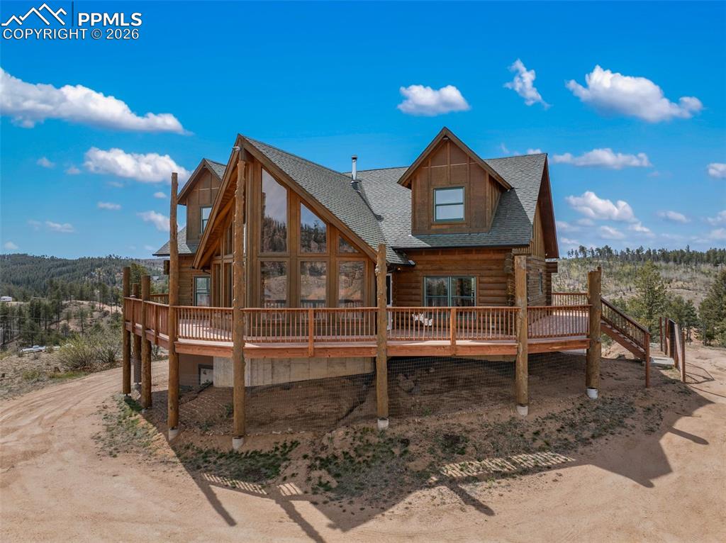 This mountain retreat is surrounded by National Forest, offering world-class rock climbing, riding, and miles of scenic hiking trails right outside your door. The home captures breathtaking views from every angle, especially from the expansive wraparound deck, perfect for soaking in the peaceful surroundings. Step inside to a light-filled living room featuring floor-to-ceiling windows that showcase the stunning landscape. The open-concept layout seamlessly connects the living, dining, and kitchen areas, creating an inviting space ideal for entertaining or simply relaxing in the beauty of the mountains. Just off the living room, you’ll find the spacious primary suite complete with a walk-in closet and a private bathroom featuring a relaxing soaking tub. Upstairs, a large loft overlooks the living area and offers an additional family room, with two oversized bedrooms positioned on each side providing plenty of space for guests or family. The unfinished basement is ready for your vision, add additional bedrooms, a theater room, or create the ultimate custom space to fit your needs. Turkey Rock Ranch Association offers an optional paid membership that provides access to the TRRA cabin, cornhole, horseshoes, a 6-hole frisbee golf course, and much more for added mountain community enjoyment. With endless potential, this home is a fantastic opportunity for future investment or a long-term mountain retreat to enjoy for years to come.