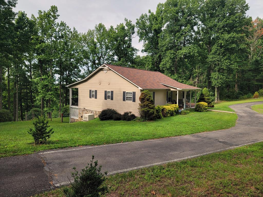 Welcome to this beautifully updated home in Skyland Lakes Subdivision, ideally located just off the Blue Ridge Parkway in Fancy Gap and only five miles from I-77. Surrounded by mature trees and abundant wildlife, this peaceful mountain setting offers a wonderful neighborhood atmosphere, golf-course access and plenty of space for comfortable year-round living or a relaxing getaway.  Situated on 1.235 acres, the property features a paved circular driveway, underground utilities and a fenced backyard adjoining the 13th green of Skyland Lakes Golf Course. Nearly 1,000 square feet of open Trex decking—installed in 2020 and still looking nearly new—provides exceptional space for outdoor dining, entertaining, grilling or simply enjoying the quiet wooded surroundings. The backyard also includes a stone patio and firepit, creating another inviting place to unwind while watching the area's abundant wildlife.  Inside, the 2,307-square-foot home offers four bedrooms, three full baths and a comfortable open floor plan with newer flooring and fresh paint. The completely renovated kitchen is truly a standout—the pictures say it all—with attractive cabinetry, extensive counter space, a stylish tile backsplash, breakfast bar, pantry and adjoining breakfast nook overlooking the deck and golf course.  The main living area is bright and welcoming, with vaulted ceilings, recessed lighting and a freestanding propane fireplace. The primary bedroom opens directly onto the rear deck and includes a private bath with a tiled shower, allowing you to enjoy convenient main-level living and peaceful views just outside your door.  The finished lower level adds excellent flexibility with a spacious family room along with a bedroom, full bath and a secure room that could serve as an office, safe room or additional storage. A 15'6" x 29'4" unfinished workshop provides plenty of room for projects, hobbies and equipment. Laundry is available on both levels. The property offers outstanding garage, work