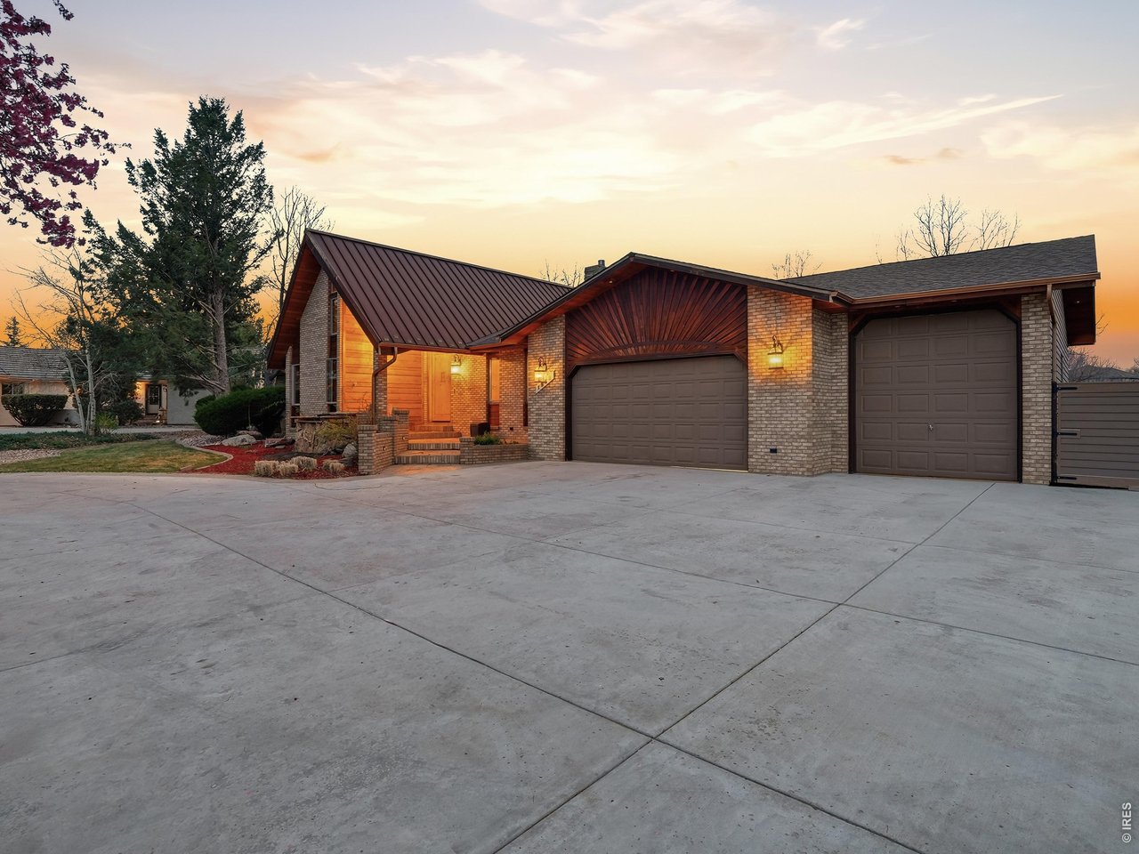 Welcome to this one-of-a-kind custom home blending rustic charm with Tuscan elegance on a spacious .48-acre lot with stunning mountain views in (unincorporated Larimer County). The stamped & colored concrete driveway, gated trailer parking, & oversized 3-car garage-including a 12' wide/deep third bay-set this property apart from the start. Durable roofing includes standing seam Corten steel & Class IV impact-resistant shingles (1 year old).A dramatic 4'x8' custom front door opens to a slate foyer with a mountain range mosaic. The vaulted living room showcases exposed wood beams & a floor-to-ceiling brick fireplace with herringbone detail. The custom kitchen features knotty alder cabinetry, a durable granite island with dramatic natural veining, stunning hammered copper farmhouse sink, under-cabinet lighting, & heated travertine floors in a Versailles pattern extending into the dining area. High-end appliances include a 48" Viking gas cooktop, double ovens with warming drawers, pot filler, prep sink, built-in coffee station, & beverage cooler. The dining room is highlighted by a custom copper coffered ceiling & convenient pass-through from the kitchen. The main-floor office includes a private loft with a wrought iron railing. The primary suite offers vaulted ceilings, walk-in closet, vanity area with built-in coffee maker & mini refrigerator. The show stopper is the luxurious oversized European-style shower with dual heads & rain showerhead feature. The outdoor living space was designed for entertaining with a expansive deck & solid pergola built with imported Canadian timber, hot tub, fire pit with seating for 8 people, & a tranquil koi pond with bridge & water feature. Out back you will also notice a garden area filled with organic soil & an indoor/outdoor dog run. Downstairs is a full basement, rec room, bedroom with an en-suite bathroom, media or gaming room, huge laundry room & several storage areas. Seller recently paid for appraisal, value came in at $935,000