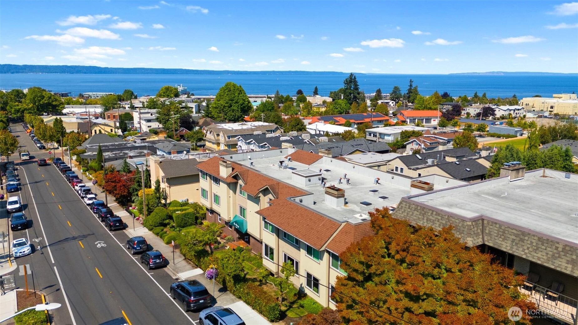 Flooded with natural light and offering multiple places to relax and enjoy sunset colors and the vibrant rhythm of downtown Edmonds, this condo is truly special. Ideally located across from the Edmonds Library and steps from the revitalized Civic Field, you’ll experience the best of walkable Edmonds right outside your door. As a corner unit with both a formal front entrance and a convenient level side-door, this home lives like a private residence. Designed with a circular floorplan, the bright, spacious living room flows easily into the formal dining area and kitchen with eating space. Two generous bedrooms on opposite sides of the unit provide valued privacy, and the dedicated laundry room and formal entry make the home feel truly residential. Two sunrooms, one on each side of the home, offer rare flexibility. They function beautifully as home offices, reading nooks, hobby rooms, or peaceful sitting areas to enjoy changing light throughout the day. Sun-filled and serene, this inviting condo offers a rare blend of charm, convenience, and community in downtown Edmonds. Welcome home!