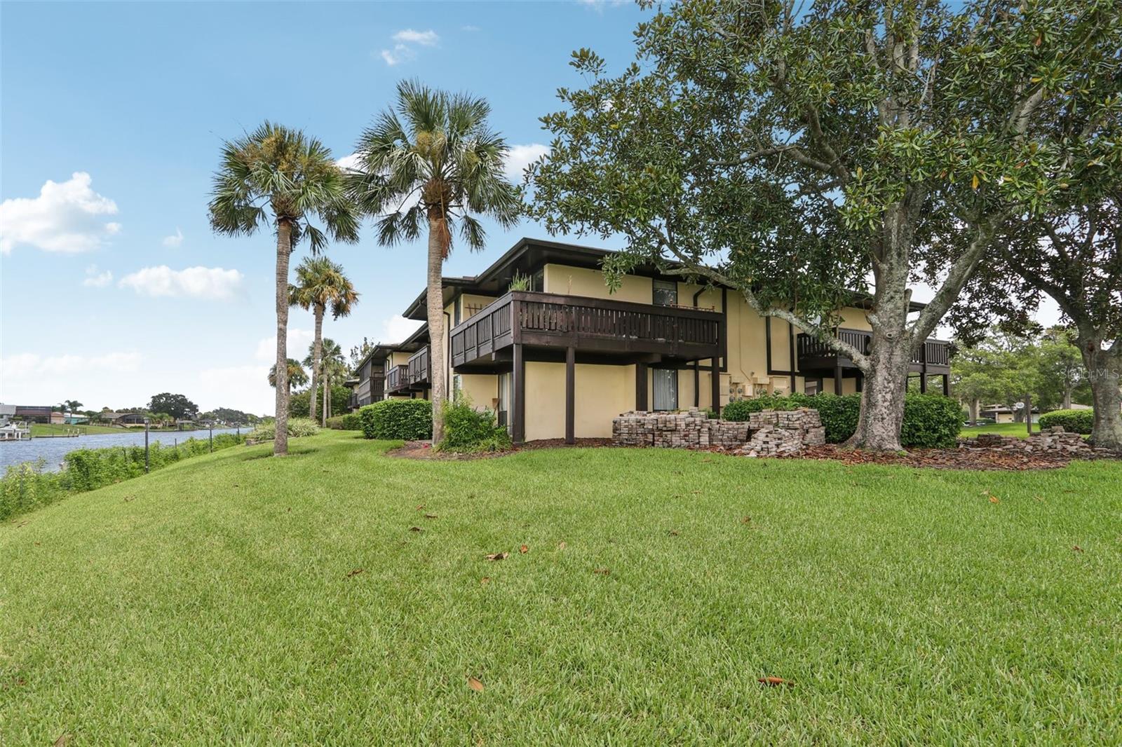 One or more photo(s) has been virtually staged. PRICE REDUCTION! All Assessments Paid in Full! New Sea Wall on Saltwater Canal! Ground floor New Roof on Building! Concrete Patio with Canal View! 2-bedroom, 2-bath condo beautifully renovated with 2023 Lennox HVAC for comfort and efficiency in the 986 sq ft living space. The fully renovated kitchen features modern light gray cabinetry, stylish countertops, and New stainless-steel range and microwave. Contemporary luxury vinyl plank flooring flows throughout the open dining and living area, where sliding glass doors lead to two private concrete patios with view of the saltwater canal.  The spacious primary suite with covered patio and canal view, a large walk-in closet, and updated ensuite bath. The second bedroom has a renovated full bath with tub/shower combo. Freshly painted in light, bright tones, this home also features tile floors in the kitchen and baths and ceiling fans. The Palm Club community offers resort-style amenities including a pool and clubhouse. The $522 monthly fee includes water, trash, cable, internet, pest control, maintenance of the building exterior, pool and clubhouse.  A public golf course is across the street enhancing the Florida lifestyle. Enjoy comfort, style, and location — all in the heart of Palm Coast!