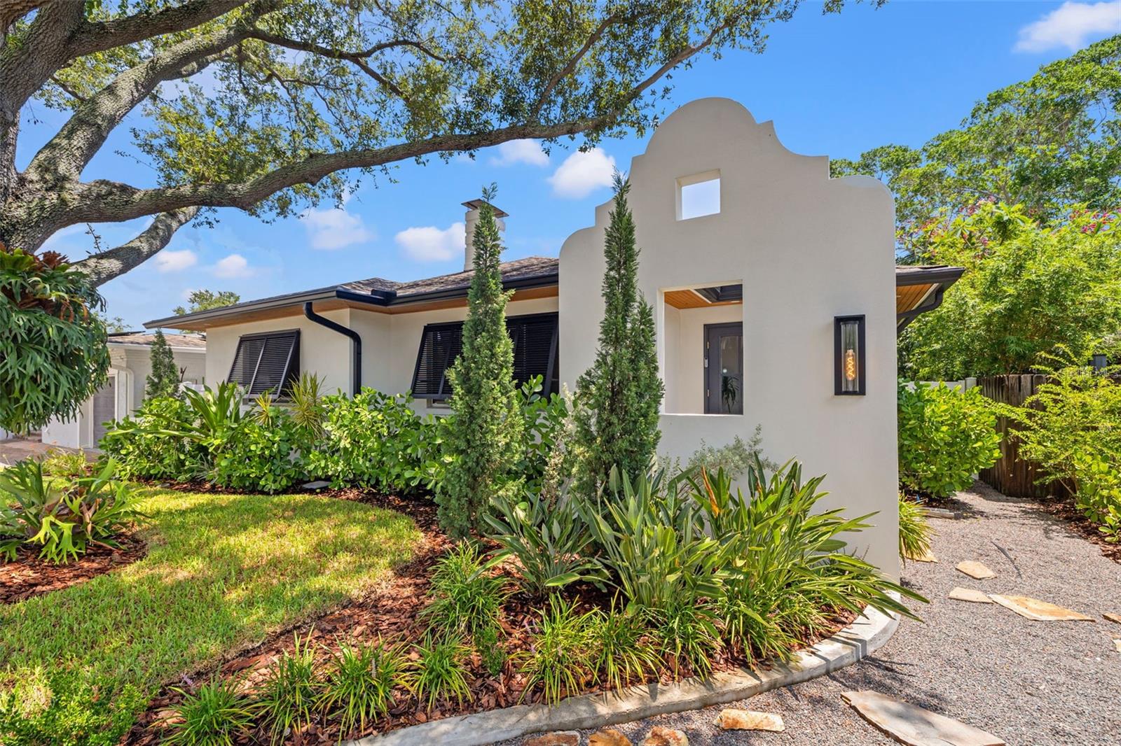 Where luxury meets lifestyle in the heart of Granada Terrace.
Step into a one-of-a-kind showpiece just steps from Coffee Pot Bayou and a short stroll to downtown St. Pete. Completely reimagined with a designer’s touch, this home blends sophisticated Dutch West Indies architecture with modern upgrades inside and out.

The exterior stuns with artisan-crafted Bahama shutters, architectural entryway, and a cozy backyard fireplace — all surrounded by lush new landscaping, sod, and lighting that makes the whole home glow at night. Inside, every inch has been elevated: herringbone luxury vinyl floors, custom trim and wainscoting, and statement lighting that belongs in a design magazine. The kitchen is pure culinary theater with custom white oak cabinets, brass details, high-end Fisher & Paykel appliances, and an LG Smart refrigerator with craft ice.

The living room features a raked plaster fireplace and custom walnut dry bar — perfect for entertaining. The spa-worthy bath wows with a tiled arch shower entry and brass accents, while custom closets keep everything beautifully organized.

This isn’t just a home — it’s a statement. A short walk to waterfront paths, vibrant downtown dining, and everything that makes St. Pete living iconic.