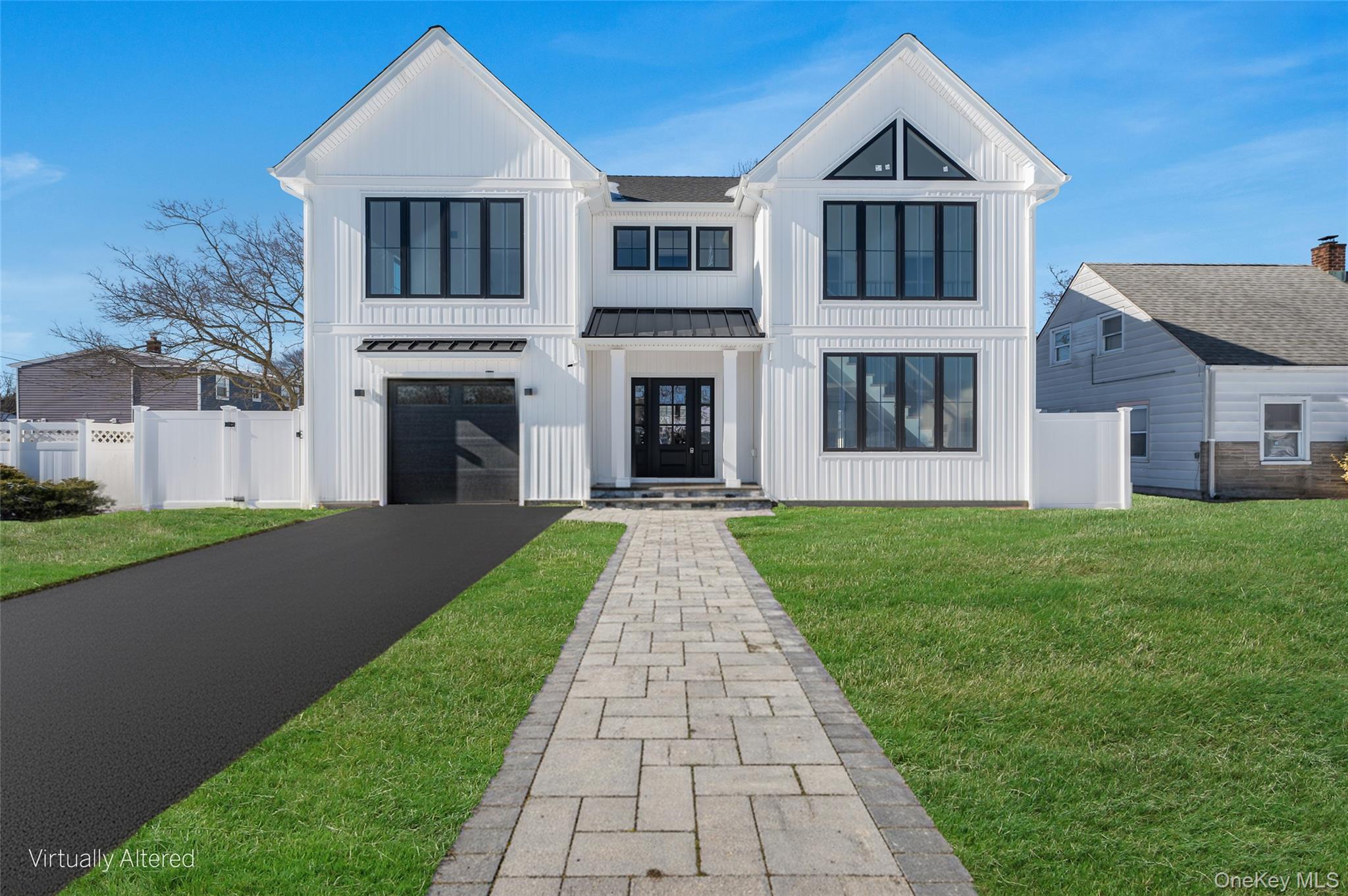 Brand new eastern facing Colonial offering over 3,100 sq ft of thoughtfully planned living space, plus a full basement with high ceilings and an outside entrance, providing exceptional versatility for both today and the future.The exterior sets the tone with clean architectural lines, board and batten style siding, black framed windows, and a welcoming covered entry that gives the home strong curb appeal and a custom built presence.Inside, oversized Andersen windows fill the home with natural sunlight, highlighting the open layout and airy feel. The main level flows effortlessly from the spacious living area into a beautifully designed kitchen with a dedicated dining area and large glass sliders to the yard. The kitchen is anchored by a waterfall edge quartz island, two tone cabinetry, and a full suite of Forno appliances. A standout feature is the first floor junior primary suite with a full bath, ideal for guests or a private office. Enter from the garage into a built in mudroom area with bench seating and hooks for bags and jackets. A powder room completes this level.The staircase serves as a design focal point with its modern railing and dramatic window wall, bringing light into both floors and enhancing the home’s architectural character.Upstairs, the primary suite feels like a true retreat with vaulted ceilings, large windows, two walk in closets, and a beautifully designed private bath featuring a freestanding soaking tub, oversized glass shower, and modern finishes. Three additional bedrooms are all well proportioned and share a full hall bath. The second floor laundry room adds everyday convenience to the layout.The full basement with high ceilings and an outside entrance offers outstanding potential for future finished living space, a recreation area, gym, or additional storage.Additional features include central air, an energy efficient electric heat pump heating system, propane cooking, sewer connection, 4 inch hardwood flooring throughout, and the ease and efficiency of new construction.Set on a 60 x 100 property within the Levittown School District, this home delivers a rare combination of space, natural light, architectural detail, and modern systems in a brand new build.Buyer responsible for water tap fee, transfer tax, and final survey fee.