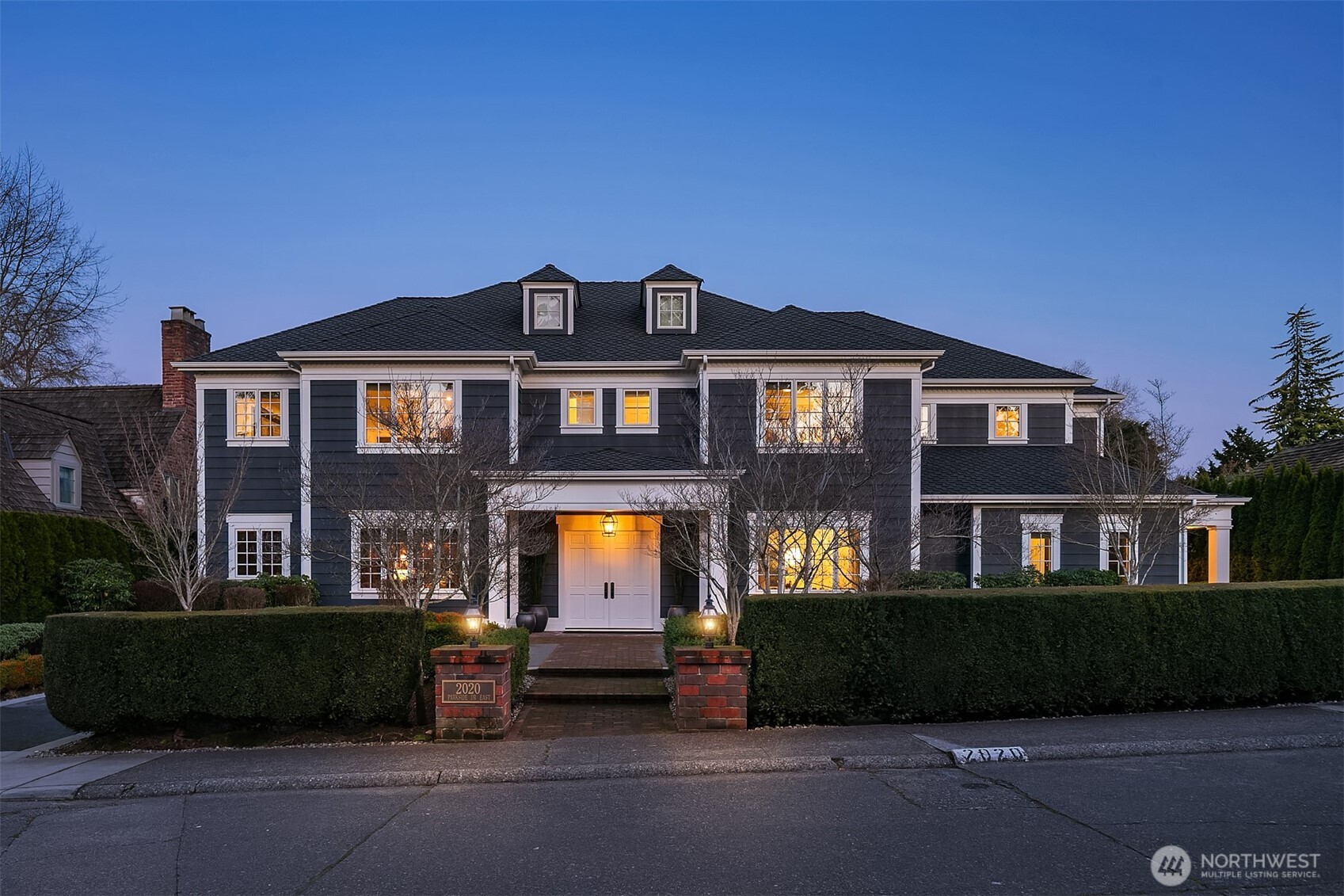Exquisite and meticulously maintained, this like-new 2014 custom home seamlessly blends timeless Broadmoor elegance with sophisticated, tech-forward living. Designed for exceptional entertaining, the main level offers gracious and inviting gathering spaces that open to a lush, verdant backyard. A chef’s kitchen is anchored by an expansive island and appointed with marble countertops, top-tier Sub-Zero and Wolf appliances, a walk-in pantry and a fully equipped butler’s pantry ideally located off the dining room. A richly wood-paneled office with floor to ceiling bookshelves and an adjoining wine room adds warmth and character. The luxurious main-floor primary suite is a lovely retreat, featuring a five-piece bath and an expansive walk-in closet designed for exceptional organization. An efficient mudroom with laundry and ¾ bath offers convenient access from the exterior portico and rounds out the main floor. Upstairs, a casual rec room with wet bar and a private fitness room (or 3rd bedroom on this floor) create a true resort-caliber experience. Two additional ensuite bedrooms, a 2nd laundry room, and generous storage complete the upper level. The detached two-car garage features a golf cart garage, dedicated shop area and ~900sf of beautifully finished living quarters above with one bedroom, a full bath, kitchen and living space. Located within Seattle’s premier gated community, this exceptional residence delivers serene luxury on one of Broadmoor’s most coveted streets.