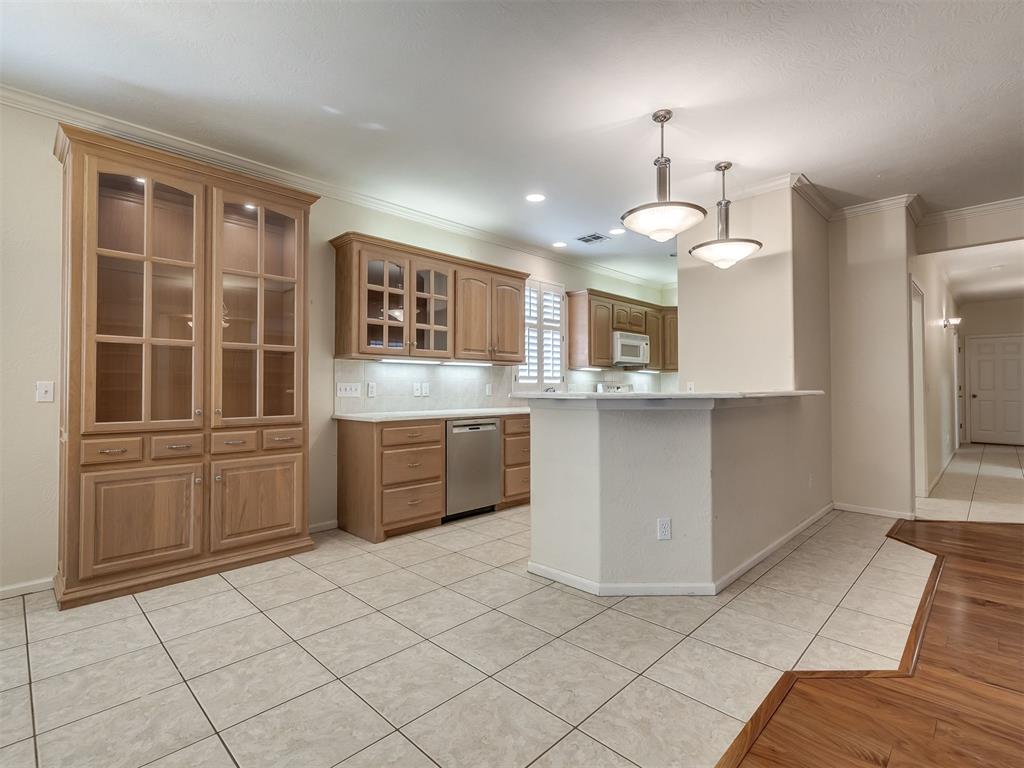 Located in the desirable Greenbriar Eastlake Subdivision, this open-concept patio home may be just what you’re looking for. From the moment you enter, you’re welcomed by open spaces and abundant natural light. The living room, dining area, and kitchen form the heart of the home, creating an easy, comfortable flow for everyday living and entertaining. Just off the entry is a nicely appointed study featuring a built-in desk, bookshelves, and a closet.  The primary suite offers built-in storage and a cozy nook, while the en suite bath includes a step-in shower with seat, whirlpool tub, and a spacious closet. The kitchen provides ample counter space and storage, along with a convenient breakfast bar, and the dining area is enhanced by a charming built-in hutch. The living room is highlighted by warm wood-look flooring, custom built-ins, and a gas fireplace. The thoughtfully designed layout places the primary suite on one side of the home, with a hallway on the opposite side leading to a second bedroom, full bath, laundry room, and garage entrance. The large laundry room features counters, cabinets, and flexible space perfect for crafts or sewing. Additional touches throughout the home include plantation shutters, crown molding, and lots of custom built-ins. The garage offers exceptional functionality with two storm shelters—one in-ground and one above-ground—plus a walk up attic (stair not ladder) with generous storage. Enjoy outdoor living on the covered back patio. Community amenities include walking trails, a clubhouse, pool, and tennis and pickleball courts. The HOA handles your lawn mowing and exterior painting, making this a wonderful option for low-maintenance living.