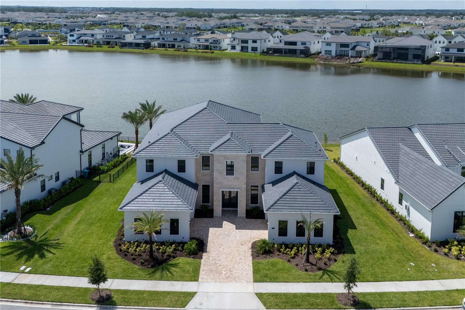 One or more photo(s) has been virtually staged. One or more photo(s) have been virtually staged.
Welcome to a stunning newly built Toll Brothers residence, offering the pinnacle of modern luxury living in the distinguished gated community of Laurel Pointe, Lake Nona. Set on a premium lakefront lot, this exceptional home spans 6,632 square feet of refined interior space, combining elegance, functionality, and a sleek contemporary design with no carpet throughout.

With 5 spacious bedrooms, a thoughtfully designed cabana bathroom, and two dedicated office spaces—one on the first floor and another upstairs—this residence is ideal for families, professionals, and entertainers alike. Whether working remotely, studying, or managing a business, you’ll find inspiring spaces tailored for productivity and privacy.

The expansive open floor plan is highlighted by soaring ceilings, clean architectural lines, and seamless indoor-outdoor flow, allowing natural light to illuminate every corner of the home.

At the heart of the home lies a chef-inspired gourmet kitchen, equipped with top-of-the-line appliances, a large center island, and exquisite finishes. The kitchen effortlessly connects to the dining and living areas, creating an inviting space for family gatherings and hosting guests.

Retreat to the luxurious primary suite, a true private haven overlooking serene lake views. The spa-style en-suite bathroom features an oversized glass-enclosed shower, modern freestanding soaking tub, dual vanities with smart mirrors, and sleek cabinetry—all curated with designer finishes for a refined experience.

Additional highlights include a private movie theater room, perfect for cinematic evenings at home with family and friends.

Step outside to enjoy breathtaking lake vistas, beautifully landscaped surroundings, and a covered patio ideal for al fresco dining or relaxing by the water’s edge. The cabana bath ensures convenience for outdoor living and future pool use.

This brand-new construction by Toll Brothers offers modern finishes, energy-efficient systems, and the comfort of move-in-ready luxury.

Laurel Pointe offers residents an exceptional lifestyle within the Lake Nona master-planned community, known for its innovation, wellness, and connectivity. Enjoy access to scenic trails, parks, art installations, and an autonomous shuttle service that connects the neighborhood to nearby attractions and amenities. You're just minutes from Lake Nona Medical City, USTA National Campus, Orlando International Airport, and a curated selection of shopping, dining, and entertainment.

With dual 2-car garages, abundant storage, and an unbeatable location, this home presents a rare opportunity to own a piece of Central Florida’s most dynamic and sought-after community.

Schedule your private showing today and experience elevated lakefront living in Lake Nona’s Laurel Pointe.