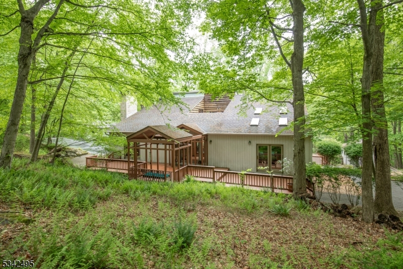 Unique custom-built Contemporary Residence w/modernist viewpoint set on 3 + private, wooded acs, surrounded by mature tree lines. Approx- 4,000 sq ft of stylish living space w/4 bedrms & 4.5 baths, W-O low lvl & 2 car built-in garage. Tranquil cul-de-sac w/striking mountain views, resort-style heated gunite pool w/sep circular spa, paver walkways & several intimate patios.This unique property is characterized by lush landscapes, (2000 built) 2-story artist's studio/home office w/built-in wall unit, hardwd flrs, marble-tiled powder rm w/low level providing storage rm, office, intimate patio,+ 2 car attached garage. Fine craftsmanship highlight open 12-rm flr plan. Unique design element is a serene Japanese Zen Garden tucked into interior courtyard, showcased by large windows thru-out home. Amenities incl window walls, wide plank hardwd flrs, soaring tongue-in-groove wd panel ceilings, 2 fireplaces & wood stove. Remodeled  LR w/wet bar steps up to DR, Great Rm anchored by stone, wood burning FRPLC, tree top deck overlooks pool area and mountain views. Chef's kitch w/granite top center isle, top grade s/s appliances & 2 story breakfast area. 2-story first floor primary bedrm w/ flr to ceil stone, gas-log frplc, & en-suite bath. A bedrm/office, full bath, 3rd bedrm complete 1st lvl. Spiral staircase opens to remodel 2nd bedrm suite w/spa bath & entertainment rm. Walk-out, daylight low lvl opens to pool area,  rec rm w/wd burning stove & wet bar, steam spa bath w/exercise area.