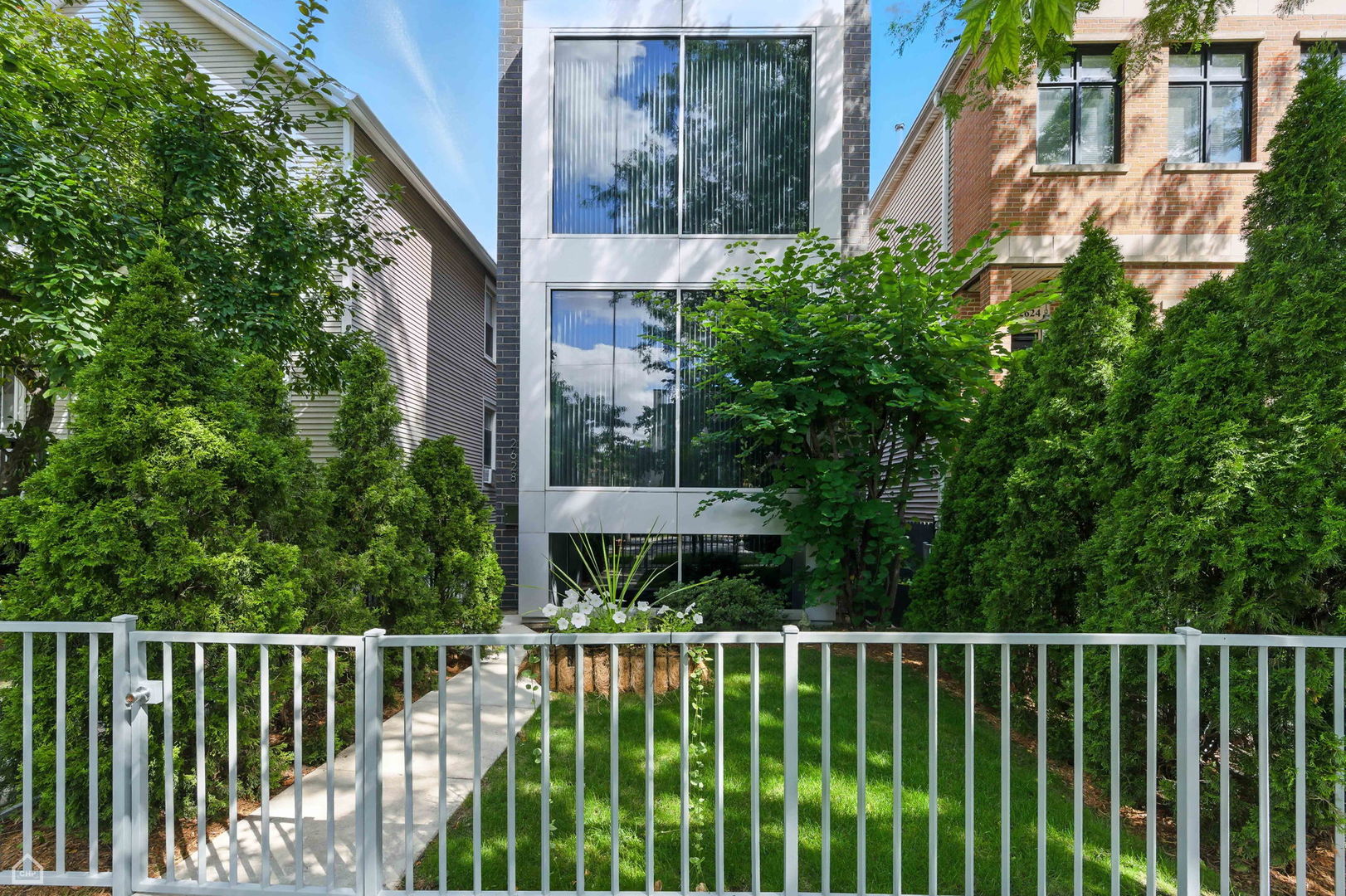 Welcome to this beautifully updated single-family home tucked away on a quiet, tree-lined street. This residence offers style and supreme functionality.   The living room makes a striking first impression with dramatic floor-to-ceiling windows and a statement fireplace. The adjacent dining room is accentuated with a tray ceiling and a built-in wet bar and wine fridge. At the heart of the home is a chef's kitchen, featuring an oversized quartz island with waterfall edges, top-of-the-line appliances, flat-panel cabinetry, and a built-in espresso machine. The kitchen opens directly to a large rear deck and a generous rooftop deck atop a two-car garage.       Located upstairs are three spacious bedrooms and a sunlit primary suite that easily accommodates a king-size bed and companion nightstands. The primary suite features a professionally organized walk-in closet and a luxurious en-suite bath, with dual vanities, a double-entry steam shower, and generous storage. A second-floor laundry hookup adds to the home's smart design.      The lower level expands living space with a family room, two additional bedrooms, a full bath, more storage, and a second laundry room. Additional highlights to note include hardwood floors, fresh paint throughout, Hunter Douglas window treatments, a security system, a central vacuum, and dual-zone HVAC.      Ideally located just blocks from the 606, local shops, restaurants, and the CTA Blue Line, this move-in-ready gem checks every box for modern city living at its best!