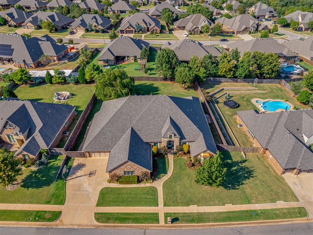 BEAUTIFUL Resort-Style, Multi-Generational retreat in Edmond! This extraordinary home offers over 5,000 sq. ft. of luxury living designed for entertaining, relaxing, and multi-generational comfort. With 4 bedrooms, 3.5 bathrooms, 2 living areas, 2 dining spaces, a game room, private theatre room, and a designated office, there’s room for every lifestyle. The thoughtful 3-way split floorplan provides both privacy and flexibility. The primary suite features its own private living area and spa-like bath, creating a true retreat. The second suite also includes an attached living space, perfect for extended guests, in-laws, or a quiet getaway. With five walk-in closets, storage is abundant throughout the home. Designed with both elegance and function in mind, the spacious kitchen and dining areas set the stage for gatherings of any size. Entertain in style with multiple living spaces, host family movie nights in the theatre room, or enjoy fun and games in the large game room. The designated office adds even more flexibility, ideal for working from home in comfort. Step outside to your own private paradise. The resort-style heated pool with an overflowing hot tub is the centerpiece of an entertainer’s dream backyard. But don't miss the amazing gas fireplace in a huge entertainment space and a great outdoor kitchen! Whether you’re hosting parties, relaxing under the stars, or soaking up the sun, this outdoor space delivers year-round enjoyment. A 4-car garage completes the package, providing room for vehicles, hobbies, or storage. From its resort-style amenities to its versatile floor plan, this home is more than a residence—it’s a lifestyle statement. Don’t miss your chance to experience this exceptional Edmond property in a quiet private neighborhood that blends luxury, function, and fun all in one!
