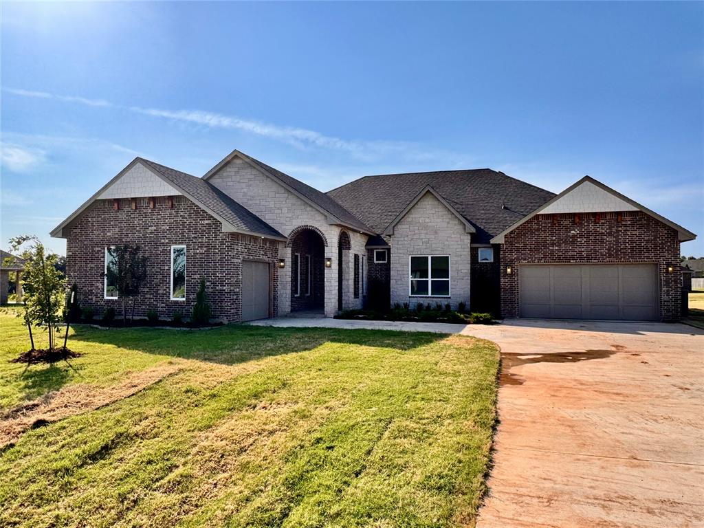 This new construction home offers approximately 3,264 square feet with five bedrooms, four-and-a-half bathrooms, and a three-car garage. A wide hallway leads into an open living area featuring a fireplace with custom built-ins and wood-look tile flooring throughout the main spaces. Twelve-foot telescoping glass doors open to a large covered back patio. The kitchen includes ceiling-height custom cabinetry, thick quartz countertops, floating wood shelves, under-cabinet lighting, stainless steel Samsung built-in appliances, a decorative vented hood, a large island, and a walk-in pantry with storage and a built-in sitting nook. The primary suite features a loggia connecting the bedroom, bathroom, and a study or flex space. The bathroom includes a freestanding soaking tub, a walk-in tiled shower, dual vanities, an enclosed water closet, and a walk-in closet with natural light. Energy-related features listed for this plan include a 96% efficient tankless water heater, radiant barrier roof decking, low-e Thermalpane windows, insulated and sealed ducts, multiple insulation components, and an Ecobee3 Lite thermostat. Construction details include engineered foundation review, exterior brick with stone accents (per elevation), Atlas HP42 shingles, Tyvek HomeWrap, structured wiring, and mechanical and safety features such as tornado straps, smoke detectors, carbon monoxide detectors, and a video doorbell. Interior finishes include LED lighting, upgraded light fixtures, hand-textured walls, ceiling fans in all bedrooms and living areas, an 8' entry door, quartz bathroom countertops, tiled showers, and ceramic tile flooring in bathrooms and the utility room. Kitchen features include soft-close drawers (per delivery date), full-extension glides, a built-in trash drawer, upgraded backsplash within allowance, and a stainless steel farmhouse or workstation sink. The home is located on a .77-acre (mol) lot in a community that allows outbuildings, with access to HWY 9.