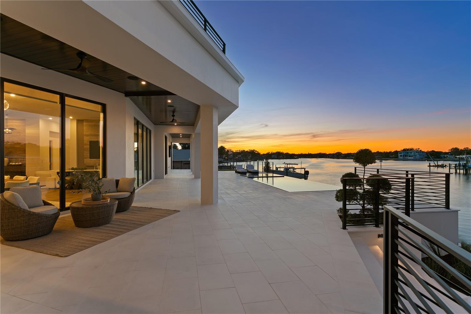 Welcome to Snell Isle Estates, St. Petersburg’s most exclusive waterfront enclave—where architectural distinction, serene privacy, and expansive open-bay panoramas converge.Crafted by Paragon Waterfront Homes in collaboration with Verve Design Co., this newly completed residence sets a new benchmark for contemporary coastal living. Tucked within a private cul-de-sac peninsula, each estate in this rare collection commands approximately 155 feet of pristine waterfront, designed to celebrate Florida’s seamless indoor-outdoor lifestyle.Inside, refined craftsmanship defines every space. European oak flooring, white oak staircases, custom all-wood cabinetry, and dramatic travertine and marble feature walls create a timeless yet modern aesthetic. The chef’s kitchen is a statement of both form and function, appointed with Wolf, Sub-Zero, and Cove appliances, quartz, quartzite, and travertine surfaces, a full bar with ice maker, and meticulously curated architectural detailing.Designed for effortless living and entertaining, the home features 12-foot ceilings on the main level, 10-foot ceilings upstairs, a three-story elevator, gas fireplace, Control4 home automation, Lutron automated shades, and ES low-E, high-efficiency windows and doors. Comfort and resilience are elevated by a whole-house water softening system by One Green Filter, dedicated RO drinking water, and a full backup generator.The expansive three-car garage boasts 16+ foot ceiling heights, ideal for vehicle lifts and serious collectors.Outdoors, the property transforms into a private waterfront retreat, featuring a fully equipped outdoor kitchen wrapped in sunshades, lush landscaping irrigated by reclaimed water, and a dock setting for a 24,000-lb boat lift—ready for life on the bay.With only a limited number of opportunities within Snell Isle Estates, this residence represents the future of luxury living on Snell Isle—a quiet powerhouse at the forefront of St. Petersburg’s next era.