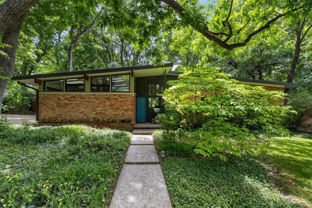 Rare opportunity to own this extraordinary Mid-Century Modern residence on one of East Dallas' most coveted streets. Welcome home to 989 N. Rustic Circle. Situated on a magnificent lot with over one third of an acre and recently renovated by Watkins Remodeling. The home features 3 bedrooms, 2 baths, 3 living areas and an office. Beautiful new white oak hardwood flooring throughout. Upon entering you immediately feel many features of a classic MCM, expansive use of glass, warm organic use of materials and an openness that brings the outdoor setting inside. The expansive floor to ceiling Chicago Brick wall in the entry area sets the stage for the warm and Rustic feeling this MCM provides. There's an extensive use of Pecky Cypress wood paneling through-out that also creates an organic and peaceful feeling. Flexible floorplan lets you express yourself and decide how you want this home to live. Gorgeous formal dining room and sitting area up front with an exposed rock wall fireplace in the back den area. There's also a fantastic family room creating several spaces to relax and hang out with your family and friends. All bedrooms have tons of natural light, and both bathrooms are the perfect blend of vintage and modernized improvements. Head up the spiral staircase and love working from your treehouse home office with its own private patio-balcony overlooking the stunning backyard.  Walk or bike to White Rock Lake, local coffee shops and the best restaurants around town! Located in the exemplary Hexter Elementary School zone.