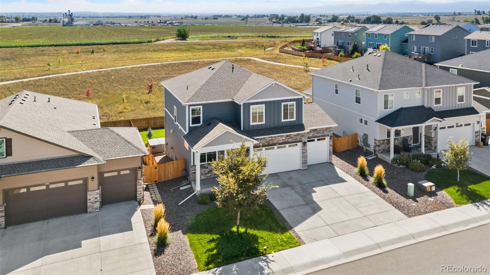 ASSUMABLE FHA LOAN WITH LOW INTEREST RATE!!!!!! This refreshed two-story home backs to open space and offers a comfortable layout, plenty of room to grow, and a setting that makes the most of the Colorado landscape. Fresh updates from top to bottom include upgraded flooring and new light fixtures, giving the interior a clean, modern feel. The foyer opens into a bright and open living area where a refinished corner stone fireplace creates a warm focal point, framed by large windows that bring in natural light. The kitchen showcases upgraded stainless steel appliances paired with quartz countertops, a pantry, and a large center island with bar seating and abundant prep space. A bonus flex area near the front entrance provides a versatile setup for a home office, study, or hobby studio. All four bedrooms are located on the upper level alongside a dedicated laundry room that streamlines daily chores. The spacious primary suite features an en-suite bathroom and a walk-in closet. The unfinished basement offers incredible potential for future customization, with a bathroom rough-in already in place. The fenced backyard backs directly toward open greenbelt acreage and features a raised deck plus an included hot tub, offering an inviting spot to relax with farm and mountain views as your beautiful backdrop. An oversized 3-car garage boasts high ceilings for added vehicle, gear, or workshop capacity. Neighborhood walking paths and parks invite outdoor recreation, while easy access to I-25, Longmont, and DIA provides swift travel across the region!