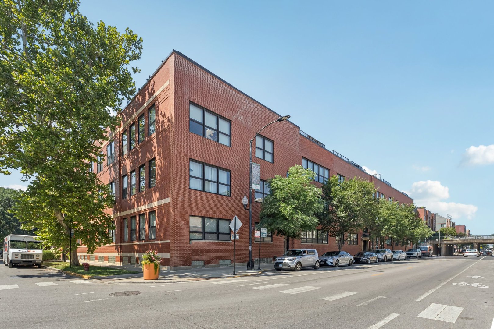 Discover the character and history of Bucktown in this stunning 3BR/1BA two-story condo at the coveted Willow Square Lofts. Once home to the Ludwig Drum Factory, this residence showcases soaring ceilings, oversized windows that flood the space with natural light, and authentic exposed brick for true loft living. Spanning more than 1,700 sq. ft., the home welcomes you with a spacious entryway featuring a convenient mud area and hardwood floors. The open-concept main living space offers a modern kitchen, expansive living and dining areas anchored by a wood-burning fireplace, and dramatic architectural details throughout. The primary bedroom on this level includes a versatile raised nook-perfect for a home office, reading lounge, or creative space. A full bath and in-unit laundry complete the main floor. The lower level has been smartly reconfigured to include two additional bedrooms, creating a flexible layout for guests, family, or work-from-home needs. Updates include a remodeled bath (approx. 7 years ago) and recent upgrades to the furnace and washer/dryer. One deeded exterior parking space and an oversized storage room are included. Residents also enjoy access to a beautifully updated exercise room, bike storage, and a spacious community rooftop deck with sweeping city views. Situated on the lively Damen corridor, you're just steps to the 606 Trail, award-winning restaurants, boutique shopping, and the Blue Line. This rare home combines space, style, and an unbeatable location-welcome to Bucktown loft living at its finest.