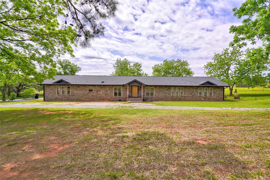 Experience the perfect blend of modern comfort and country living with this beautifully remodeled ranch-style home situated on 10 scenic acres. Offering 5 spacious bedrooms, 3 full bathrooms, and a 2-car garage, this property provides the space and functionality you've been looking for.Step inside to an inviting open-concept living area where a stunning brick wood-burning fireplace with a classic mantle serves as the centerpiece. The adjoining kitchen is designed for both everyday living and entertaining, featuring granite countertops, a large center island, chrome appliances, double ovens, a deep wash basin sink, tiled backsplash, under-cabinet lighting, abundant cabinetry, and generous workspace.A private study with French doors creates the perfect home office or quiet retreat. The spacious primary suite offers a large walk-in closet and an elegant ensuite bath complete with dual granite vanities, a beautifully tiled walk-in shower with brushed bronze fixtures, and additional storage for linens and essentials. Granite countertops continue throughout every bathroom, adding a touch of timeless style.Additional interior features include a large laundry room with mud area, granite utility sink, custom cabinetry, central vacuum system, zoned HVAC, and high-speed OEC Fiber Internet for today's connected lifestyle.Outside, the property is equally impressive. A large storm cellar provides peace of mind, while the barn/workshop with its own private entrance and gated access offers endless possibilities for hobbies, equipment, or business use. Livestock pens and fenced pasture make this property ideal for horses, cattle, or other ranching needs.Whether you're seeking a working ranch, hobby farm, or peaceful country retreat, this exceptional property delivers the perfect combination of modern updates, functional amenities, and wide-open Oklahoma living.