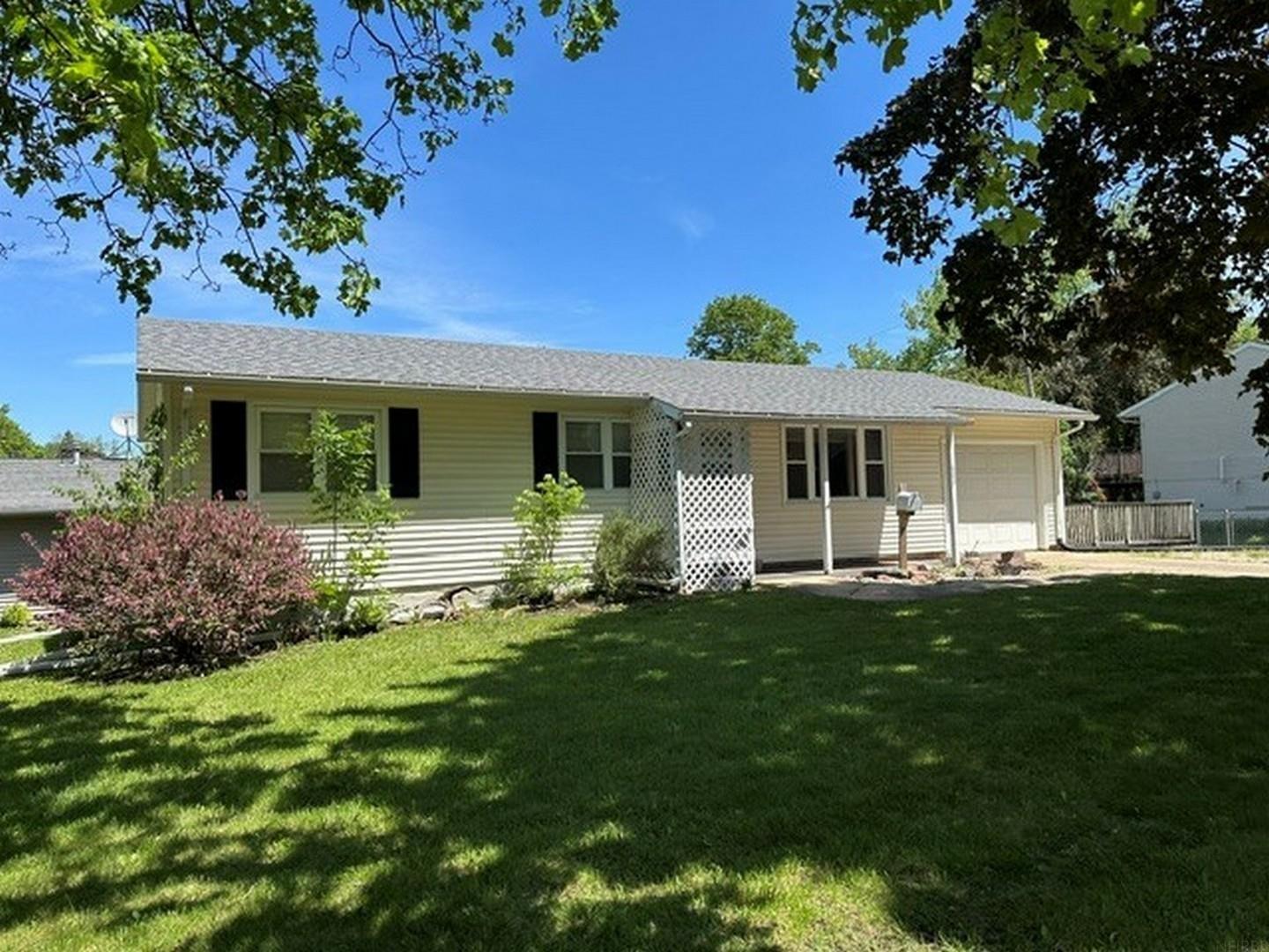 Situated on a spacious corner lot, this well-maintained 3-bedroom, 1-bath ranch-style residence offers comfortable one-level living with an attached single-stall garage. Built in 1963, the home features approximately 1,435 finished square feet of living space. Interior highlights include a functional kitchen with adjacent dining area, main-level laundry combined with a three-quarter bath, and convenient access to the attached garage. Exterior amenities include low-maintenance vinyl siding, a partially fenced backyard, and a wood deck ideal for outdoor enjoyment and entertaining.  Whether you are searching for your first home, looking to downsize, or seeking an affordable investment opportunity, this property offers comfort, convenience, and potential all in one inviting package