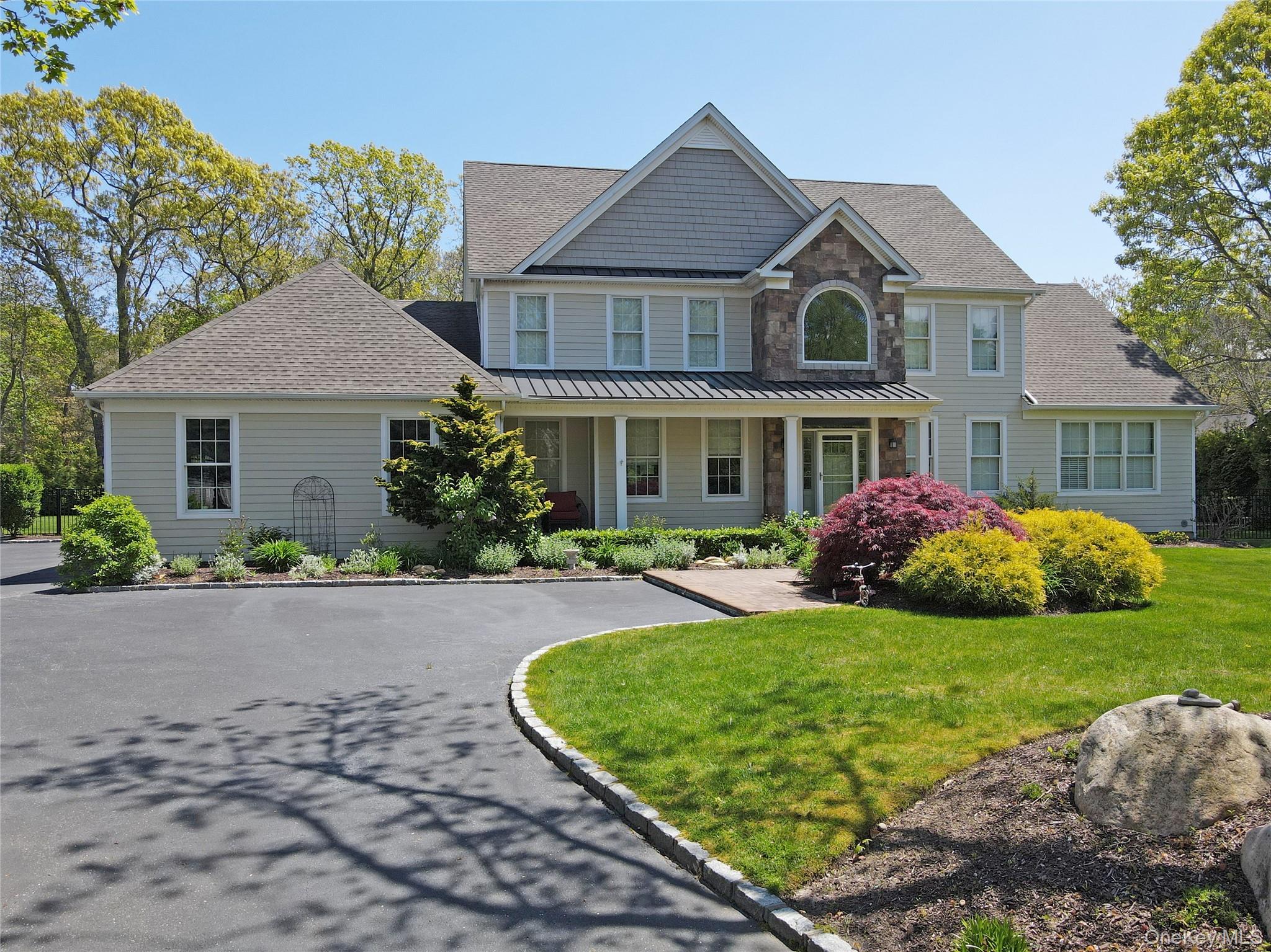 Experience Luxury and Coastal Living in Baiting Hollow. Prepare to be captivated by this stunning 2,775 sq ft residence in the charming Hamlet of Baiting Hollow. Situated on a meticulously landscaped 1.03 acre property, this home seamlessly blends elegance, comfort and modern coastal living. Featuring 3 spacious bedrooms, and a generously sized bonus room currently being used as a fourth bedroom. Three full baths and one half bath, this exceptional home is designed for both relaxation and entertainment.  The 20'x40' in-ground pool and newly installed NICOLOCK patio provide the perfect outdoor retreat, while the covered back porch-complete with a custom-cut thin stone feature wall, IPE decking, infrared ceiling heaters and roll-down weather shades-offers year-round comfort. Step inside and be greeted by soaring 11-foot ceilings on the first floor, enhancing the grandeur of the living and family rooms. The family room serves as a stunning focal point, featuring a wood-burning fireplace framed by a stone accent wall and flanked by built-in oak cabinetry. The first-floor primary suite is a private sanctuary, boasting high ceilings a walk-in closet, a pedestal soaking tub and a walk-in glass shower. The gourmet kitchen is a masterpiece, equipped with high-end appliances, white cabinetry, an oversized island and a large pantry. Nearby a mudroom area with full laundry and a half bath adds convenience. On the second floor you'll find two generously sized bedrooms and a generously sized bonus room currently being used as a third bedroom along with two full baths, providing ample space for  guests. Additional highlights include:Pull-through driveway, three car garage with overhead storage, central air & natural gas heating, in-ground irrigation system. This home is just moments from Long Island Sound beaches, acclaimed vineyards, local eateries, parks and charming boutiques. Don't miss this rare opportunity to own a luxurious coastal retreat in the heart of the Hamlet of Baiting Hollow. Your dream home awaits!