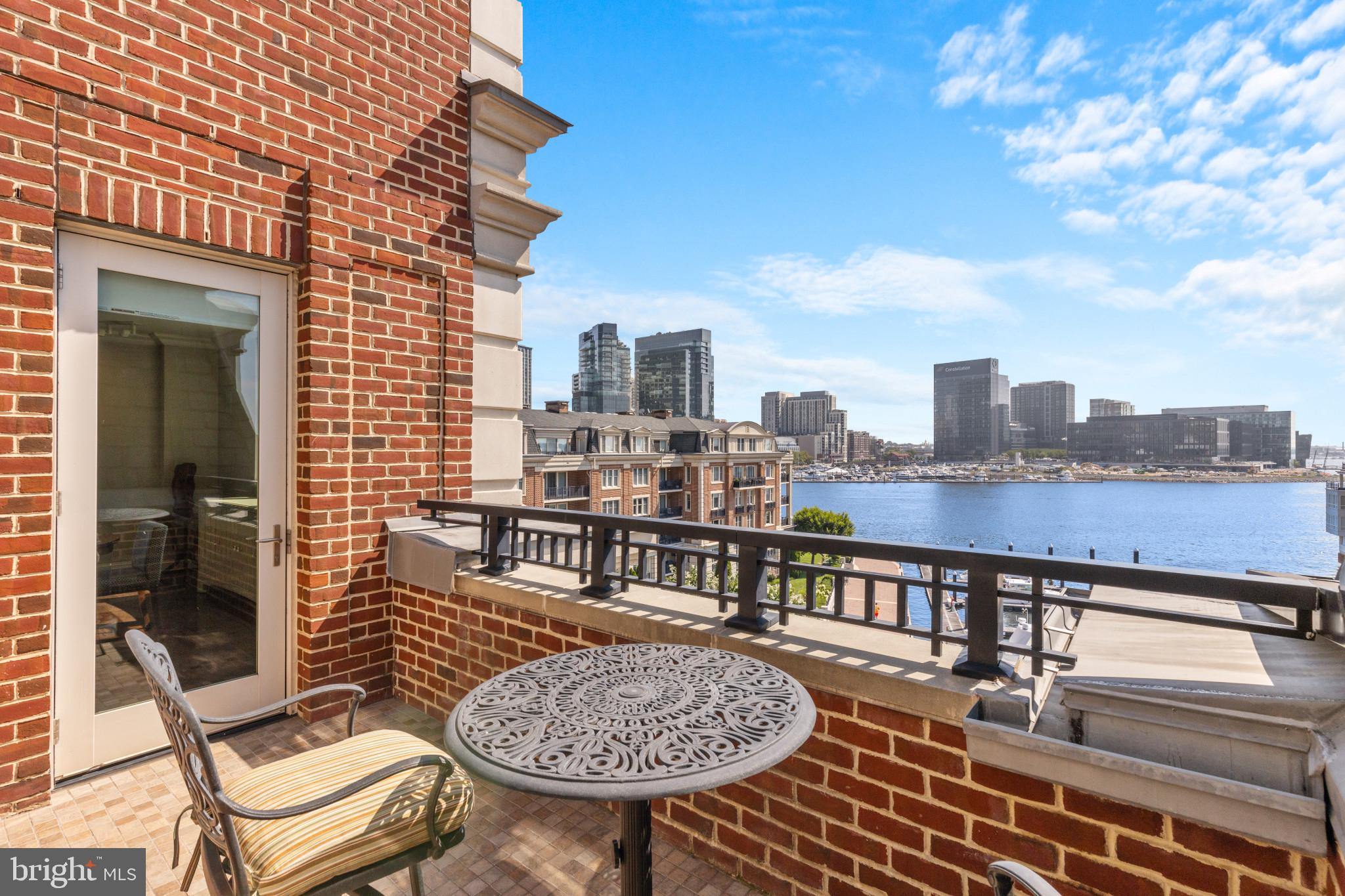 Waterfront Penthouse overlooking the harbor at The Ritz-Carlton Private Residences in Baltimore. This exquisite 2-bedroom, 2.5-bathroom, 2,133-square-foot penthouse is bathed in natural light and boasts stunning water views from every corner. The condo features high-end Viking stainless steel appliances, beautiful hardwood floors, and an open floor plan that seamlessly connects the kitchen with the dining area and a living room centered around an elegant vented gas fireplace. A private penthouse balcony extends from the living area, providing the perfect spot for morning coffee or an evening nightcap. The expansive primary suite includes a large walk-in closet and a spa-like bathroom with double vanities, a spacious walk-in shower, and a garden soaking tub. The sizable second bedroom, currently set up as an office with two built-in desk areas and perfectly accommodates a sleeper sofa, can easily be converted back into a traditional bedroom.  This room is connected to a generously sized bathroom with a walk-in shower. Every closet has been customized with a shelving system. Two deeded parking spaces and a separate storage area add to the convenience of this remarkable home. Enjoy the legendary 5-star amenities at The Ritz-Carlton Residences, including 24/7 concierge, valet, and security services, an indoor heated saltwater pool, a well-equipped gym with an additional movement room, a theater, a residents' lounge, a boardroom, a clubroom, six guest suites, multiple professional manicured garden areas, and more. Arrive directly into your private vestibule via a semi-private elevator and immediately experience the effortless Ritz-Carlton lifestyle.