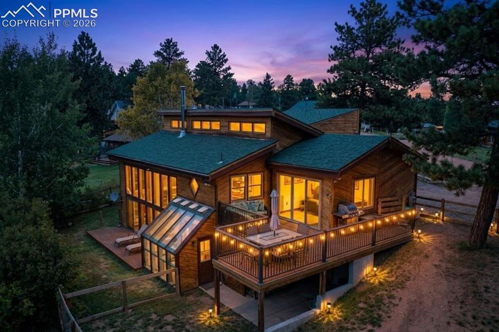 Experience the perfect harmony of sustainable design and panoramic beauty. Anchored by Trombe Passive Solar technology, this residence offers energy efficiency without compromising on style or comfort. Perched to capture breathtaking views of Pikes Peak, the home invites you to enjoy mountain living with an emphasis on natural light & unique craftsmanship.The heart of the home features vaulted wood ceilings that add warmth & architectural character to every room. The Living Area: A sprawling, carpeted space designed for gathering.Chef’s Kitchen: Equipped with granite countertops, stainless steel appliances, & a dedicated coffee bar. Ceramic & wood flooring define the space.Dining Room: Features wood flooring & vaulted ceilings, perfect for intimate meals.Bed 4: A versatile, premium-floored room featuring vaulted wood ceilings, dual Murphy beds for ultimate flexibility, & direct patio door access to the upper deck.Guest Bath: Features ceramic flooring & a single vanity.Lower Level:Family Room: An entertainer’s dream with a striking window wall, beautiful stained glass, & a wood-burning stove for chilly mountain evenings. Includes patio door access to the back deck.Master Suite: A tranquil escape with soft carpet, a distinctive bamboo accent wall, & a walk-in closet.Master Bath: A spa-like experience featuring premium flooring, a single vanity, a unique Redwood shower, plus a private dressing area.Beds 2 and 3 offer versatility, perfect as non-conforming bedrooms, offices, or hobby spaces, each with French doors & access to a shared marble-vanity bath.The Greenhouse: A gardener's paradise with tile & concrete flooring, offering direct access to the hot tub.Dedicated Office: A workspace located off the garage, providing a quiet, carpeted area for productivity.Outdoor Living: Enjoy privacy & security with a fully fenced back and side yard.Practical Additions: A 2-car garage, dedicated storage/pantry closet, & an included washer & dryer.