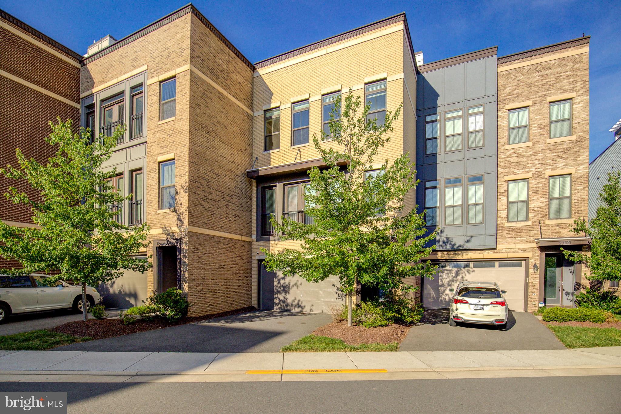 Nestled just steps away from the Brambeton Town Center, this exquisite former model townhome offers a luxurious lifestyle defined by its stunning water views from the roof top terrace. Built in 2020, this residence boasts 3,260 square feet of designer living space, where every detail has been curated for comfort and sophistication. The heart of the living area features a cozy fireplace, perfect for creating warm memories during cooler evenings and walks out to an expansive deck. The open layout encourages effortless entertaining with the fun of a custom built wet bar on the lower level. The master suite serves as a private retreat, featuring ample space and serene views that invite tranquility. Each bathroom is elegantly finished, ensuring a spa-like experience at home. This property is not just a home; it's a lifestyle. The community's amenities enhance your living experience, providing opportunities for relaxation and recreation right at your doorstep. Experience the perfect balance of luxury and comfort in this stunning townhouse, where every day feels like a getaway.
