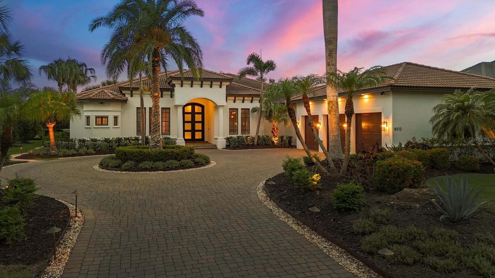 In the prestigious community of The Lake Club in Lakewood Ranch, this custom-built, extensively renovated in 2022, four-bath plus bonus room and office estate offers approximately 3,600 square feet of refined living space with a tranquil bird sanctuary preserve view. Designed by renowned builder John Cannon, this residence combines modern updates with quality John Cannon construction. The home’s exterior features a paver driveway leading to a three-car garage, complemented by lush landscaping and outdoor lighting that enhance its exceptional curb appeal. Upon entering through the custom double iron and glass impact entry doors, the expansive great room welcomes you with tall ceilings, a gas fireplace anchored by custom built in cabinetry and shelving, tray ceilings with beam detail, crown molding, porcelain wood plank tile flooring, and 10-foot pocket sliding doors that open to an expansive screened lanai. The renovated gourmet kitchen is equipped with stainless Thermador appliances, a five-burner gas stove, Sub-Zero refrigerator, under sink reverse osmosis water filter, massive island with thick stunning quartzite countertops, double beverage refrigerators, designer lighting, custom cabinets, walk-in pantry and a kitchenette with aquarium windows offering beautiful views of the pool and spa. A media/bonus room with access to the lanai provides additional space for entertainment. The oversized primary suite features tile plank floors, large walk-in closets, and a spacious main bath with dual vanities, a soaking tub and a walk-in shower. Three additional large guest bedrooms also include wood and tile plank floors, walk-in closets and their dedicated en-suite baths. A private office, off the entry, offers a sound absorption wall to ensure a quiet space for work or reading. While the separate formal dining room offers space for entertaining. The completely new laundry room features built-in cabinetry, a farmhouse-style sink, and a new stacked washer and dryer. Throughout the home, wood plank tile flooring has been installed for a seamless, upscale finish. The expansive screened lanai is designed for entertaining, featuring a heated saltwater pool and spa with new equipment including new pump, salt cell and leveler, as well as a new outdoor kitchen. Additional recent upgrades include new air-conditioning units, whole house water treatment, whole-house generator, new water heater and a Sonos speaker system with outdoor sound. Residents of The Lake Club enjoy access to a range of amenities, including two resort-style pools, Har-Tru tennis courts, pickleball courts, a fitness center, private spa, clubhouse and grand ballroom. The community’s Mediterranean-inspired design includes cobblestone streets, decorative stone bridges, fountains, scenic park areas and lush landscaping, creating a tranquil and luxurious living environment.