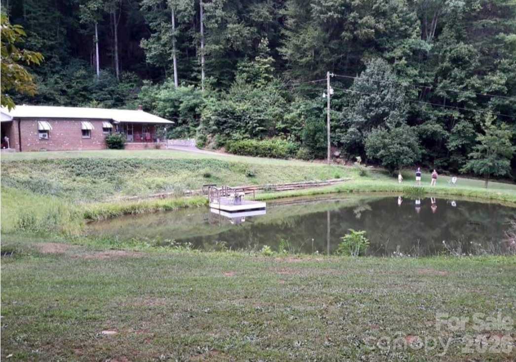 Multi-generational living with endless possibilities! Nestled on approximately 24 private acres in Lenoir, this one-of-a-kind property offers incredible potential with two homes, a versatile barn/outbuilding, a beautiful pond, and plenty of room to roam. The brick home is ready for someone with vision to bring it back to life. With some updates, repairs, and a little elbow grease, this property could truly shine. Inside, you'll find a very spacious den for large gatherings. A covered front porch overlooking the picturesque pond—the perfect spot to enjoy peaceful mornings or relaxing evenings. Spend your days fishing, exploring the wooded acreage, or simply enjoying the privacy this property provides. The second dwelling includes a living room, kitchen, one bedroom, and a full bath, making it an ideal space for an aging parent, independent teen, guest house, or rental opportunity.Please note that the brick home currently has no functioning central heat... only wall unit, which may limit financing options. Buyers are encouraged to consult with their lender regarding financing eligibility due to heat and condition of brick home. No drive-bys, please. Showings by appointment only.