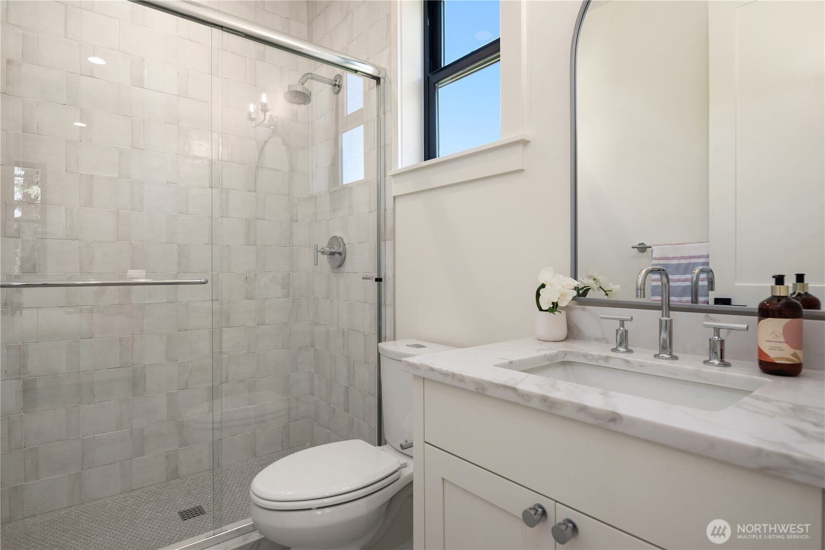 Glass enclosed shower and marble vanity