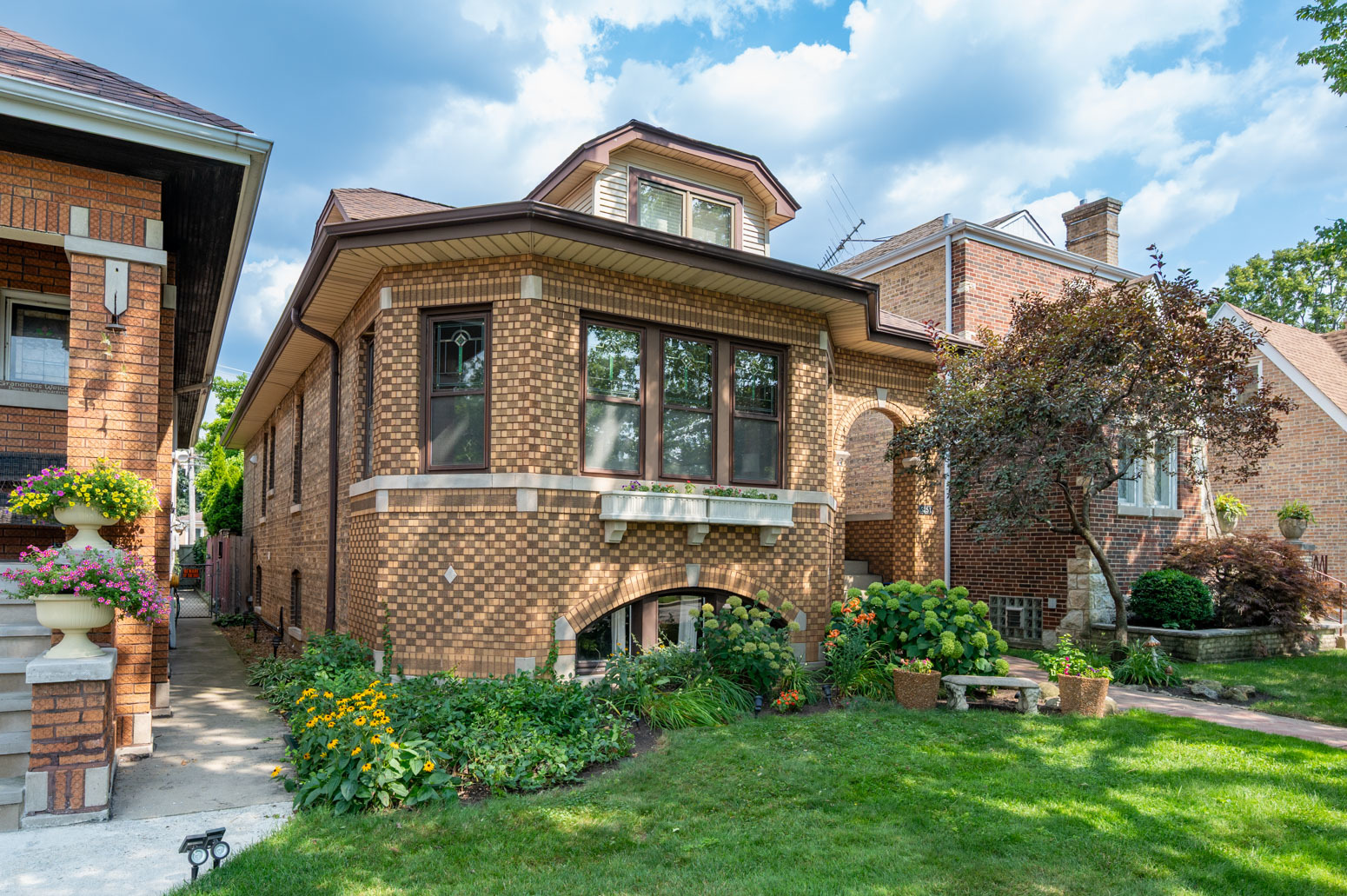 Welcome to this charming Chicago brick bungalow in sought-after and storybook Forest Glen. Step inside the sun-filled living room with original stained glass windows and woodwork, which leads to a large formal dining room with beautiful crown molding and arched doorways. The bright and airy kitchen was renovated in 2017 with quartz countertops, quality shaker soft-close cabinets, and a  breakfast bar flowing into a spacious family room with glass doors opening onto the deck. White wainscoted walls and penny tiles add charm to the first floor's full bathroom. Two bedrooms on the first floor, extra-large primary suite on the second floor with two separate bathrooms and three large closets.   BASEMENT: Full-finished basement completely gutted and remodeled with vinyl floors, a half bath, enormous storage room, wood workshop, and large laundry room.   DECK:  Enjoy a peaceful retreat on the multi-layered deck in this whimsical backyard with a gorgeous magnolia tree and lilac tree, which bloom every spring. Take a stroll on the forest preserve trail just a few blocks away in magical Forest Glen.  PLUS: Refinished hardwood floors throughout the first floor, brand new hardwood on the second floor and in kitchen, new cedar fence 2020. Easy walk to Metra. Highly rated Beaubien Elementary and Taft High School.  Dimensions: First floor 1250 sq feet; 2nd floor 1250 sq feet;   Full finished basement has 800 sq foot family room plus 450 sq feet of storage, utilities and wood shop.