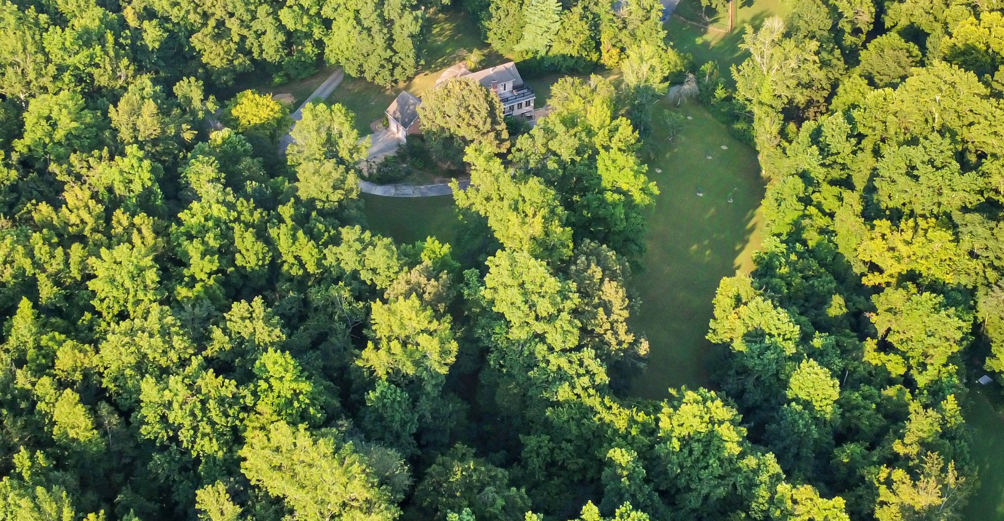 Discover a rare gem nestled on nearly 4 acres - where tranquility meets modern luxury. This meticulously renovated 5 bedroom, 4 bathroom estate blends privacy, functionality and charm. Surrounded by lush landscaping, mature trees and a serene Koi pond, the property captivates with stunning balcony views—perfect for morning coffee or evening sunsets. A thriving fruit orchard with pear, apple, peach, plum and cherry trees (some yielding fruit, others maturing) pairs with a vegetable garden featuring drip irrigation, inviting sustainable living. Wildlife flourishes, with daily deer sightings, seasonal turkeys, foxes, playful squirrels, vibrant butterflies and hummingbirds dancing through the grounds. Inside, the home unfolds like a storybook, revealing unique nooks and surprise spaces for relaxation, play or creative pursuits. A light-filled sunroom bathes the interior in warmth, while the fully renovated, enlarged kitchen boasts modern elegance. The finished basement, complete with a full bathroom and laundry, offers versatile space for multi-generational living, guest quarters or a private retreat. Car enthusiasts and hobbyists will love the garage space for up to 6 vehicles, including a detached 3-car garage with a Tesla Wall Charger, an attached 2-car garage and a 1-bay garage in the basement—ideal for a workshop or prized car collection. With close proximity to Clarksville’s shopping, dining and entertainment, this move-in ready home, with every room thoughtfully renovated, is more than a property—it’s an invitation to live intentionally, surrounded by nature’s beauty and modern comforts.