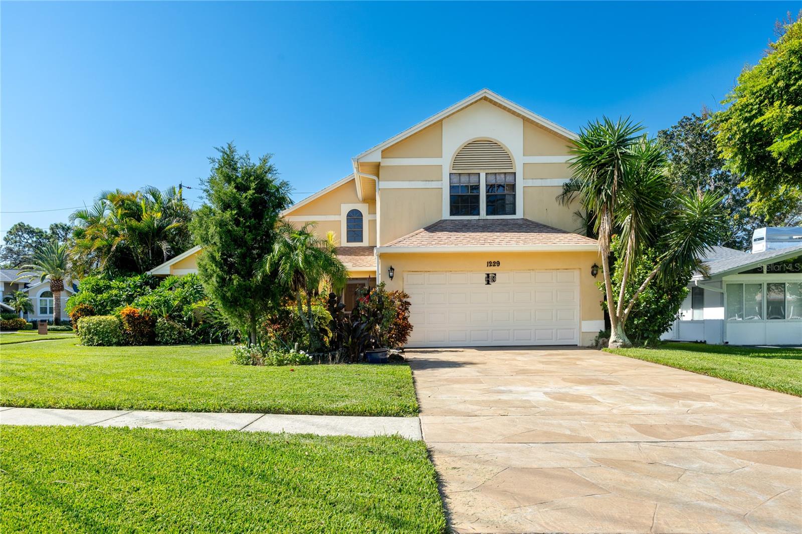 This stunning 3-bedroom, 3-bath pool home in Tarpon Springs sits proudly on an oversized corner lot, surrounded by mature landscaping and designed for both comfort and peace of mind. Meticulously maintained and thoughtfully updated, the home combines timeless style with practical upgrades, making it a rare move-in-ready find with no HOA restrictions.

Step inside to soaring vaulted ceilings, rich wood flooring, 20-inch neutral ceramic tile, and an abundance of natural light. The flexible floor plan includes a spacious 18x26’ living room and formal dining area, while the inviting family room centers around a beautiful brick wood-burning fireplace. The kitchen is a chef’s delight, featuring swirled granite countertops, a pull-up island, wood cabinetry, a tray ceiling, closet pantry, breakfast bar with pendant lighting, and a dinette space—perfect for everyday meals or entertaining. Nearly all main-floor windows overlook the pool, keeping the home bright and connected to the outdoors.

Upstairs, the expansive primary suite is a private retreat with a massive custom walk-in closet complete with California-style shelving and cedar parquet flooring. The spa-like ensuite bath offers a luminous walk-in shower with seating, his-and-her sinks, an upgraded Toto commode, and abundant cabinetry. Two additional bedrooms each include oversized vented walk-in closets, ensuring exceptional storage throughout.

This home has been enhanced with countless extras that elevate everyday living such as a central vacuum system, epoxy-finished garage floors with generous storage, newer lighting and remote-controlled ceiling fans, and updated blinds and shades throughout. For added peace of mind, it features a whole-home reverse osmosis system, and newer solar panels that power the entire home.
Outdoor living is equally impressive. The screened pool area includes paver decking, a sparkling pool, and a covered seating area that together create a true tropical oasis. A separate wood-decked space under roof is ideally suited for a future hot tub. The fully fenced yard ensures privacy and plenty of room to enjoy the Florida lifestyle year-round.

Located just minutes from Sunset Beach, Fred Howard Park, the historic Sponge Docks, marinas, and downtown Tarpon Springs, this home offers the perfect blend of tranquility and convenience. Zoned to top-rated schools and surrounded by local charm, it’s an ideal setting for both everyday living and memorable gatherings.

Beautifully maintained, upgraded with high-quality features, and free of HOA restrictions, this Tarpon Springs home truly has it all. Schedule your private showing today and experience the perfect balance of peace of mind and Florida living.