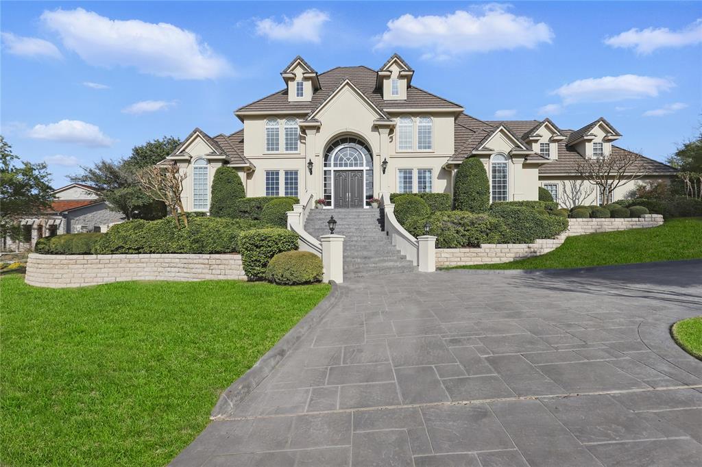 Nestled atop a hill in Fort Worth’s prestigious gated golf community of Mira Vista, this beautiful 5-bedroom, 4.5-bath home offers resort-style living with exceptional privacy and panoramic views. A grand foyer with a sweeping curved staircase and chandelier on an electric lift sets an elegant tone upon entry. The main level features a formal dining room with custom built-ins, a richly appointed office with wood ceilings and trim, and an open-concept kitchen, living, and casual dining area designed for effortless entertaining. The chef’s kitchen includes a built-in refrigerator, double convection ovens, warming drawer, microwave, and ice maker. The spacious primary suite provides a serene retreat with a sitting area, gas fireplace, and built-ins. A private guest suite, plus a laundry room with chute and pet wash station, complete the first floor. Upstairs offers a large game room with media built-ins and window seats with hidden storage, along with three bedrooms—two connected by a Jack-and-Jill bath and one with an en-suite. A custom study nook for two adds a perfect workspace. Step outside to a recently refreshed backyard paradise featuring a resort-style pool, oversized hot tub with water feature, outdoor kitchen with granite counters, bar seating, gas grill, refrigerator, and sink, plus a built-in fire pit with LED lighting and outdoor surround sound for evenings under the stars. Additional highlights include a built-in safe, security system, central vacuum, intercom, and vanishing TV in the primary bath mirror. This exceptional property blends luxury, comfort, and lifestyle in one of Fort Worth’s most sought-after communities.
