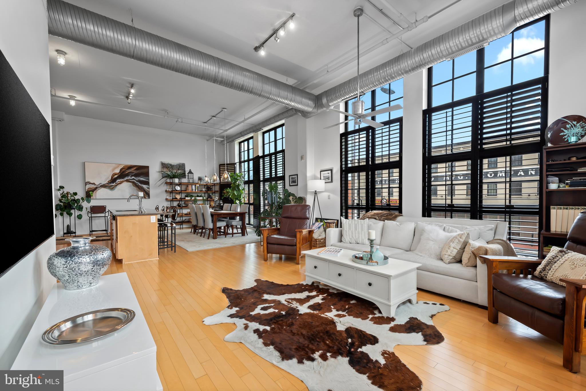 Light, volume, and unmistakable character define this residence at the historic Canal Street Malt House in the heart of Little Italy. This 2-bedroom, 2-bath condominium offers a sophisticated blend of industrial charm and modern comfort, where soaring ceilings, rich hardwood floors, and expansive windows create an atmosphere that feels both airy and inviting. Natural light pours into the open-concept living space, designed for effortless entertaining and easy everyday living. The kitchen serves as the centerpiece of the home, featuring stainless steel appliances, a gas range, built-in wine refrigerator, and seamless connection to the main living and dining areas. A full-size washer and dryer add everyday convenience. One of the building's most distinctive features is its private interior courtyard—an unexpected urban oasis that offers a sense of calm rarely found in city living. Secure entry and a dedicated parking pad provide comfort and peace of mind.Just moments from the waterfront, Harbor East, Fells Point, and downtown Baltimore, this residence places some of the city's most sought-after restaurants, cafés, and cultural destinations right outside your door. Vibrant yet relaxed, historic yet contemporary, this is Little Italy living at its best. Live where Baltimore's energy, architecture, and lifestyle come together effortlessly.