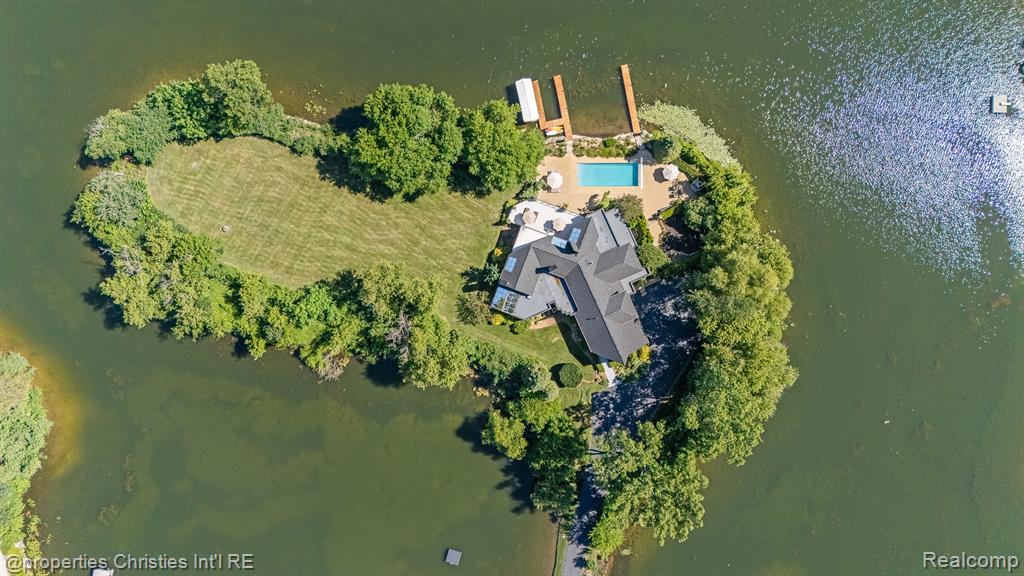 Presenting a once in a lifetime opportunity to own a private island in one of Michigan’s most exclusive all sports lake communities. With a local reputation of prestige and mystique, Lake Sherwood is the pinnacle of lakefront communities in affluent Oakland County and is surrounded by the most bustling upscale metropolis’ in the country, just minutes from downtown Milford. 4912 Oakwood Court is a nearly 1.6-acre legacy parcel tucked at the way back of a conveniently situated cul-de-sac that enjoys 1,500+ feet of prime waterfront and, without its long and elegant tree lined driveway, would be entirely surrounded by pristine waters. This rare island is improved by an architectural masterpiece, a timeless estate home designed to be acquired by a buyer that understands its place as the pride of a truly private, residents only lake. This home features a plethora of natural sunlight, rustic stone fireplaces complete with imported limestone mantles, WOLF appliances, and lustrous white maple hardwood flooring, together crafting one of the finest residences in the state. The fluid layout, and extremely thoughtful features offer the highest degree of functionality for any lifestyle; ultimate control and privacy is one of the many benefits this property offers. The spacious terrace overlooking the resort style pool complete with a breathtaking lake view sits just steps away from the Northern Michigan grown cedar docks that your grandchildren will walk on, which offer permanent docking solutions for your boats. Situated in the “no wake” part of the lake, this ONE of ONE property is mere seconds from the vast oasis that is Lake Sherwood. Every part of the property offers jaw dropping lake views, including the towering outdoor fireplace just off the pool. Complete with spacious and well-manicured rolling grounds fit for a tennis court, an additional structure, or whatever else you decide to feature, this incredible estate is an asset to enjoy and design a lifestyle around.