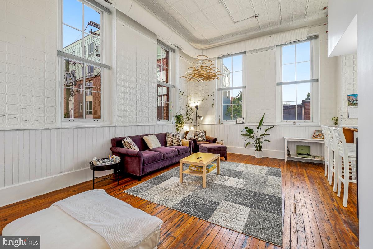 Major price adjustment! Priced for immediate sell! Experience the epitome of city living in this exquisite 19th century school conversion building, where sophistication meets comfort in a beautifully designed Colonial-style residence. Spanning 1,384 square feet, this exceptional tow levels two-bedroom, two baths condominium with a loft offers an open floor plan that seamlessly blends the dining and living areas, with original stamped tin on the walls and ceiling, and original wainscoting. Step inside to discover 14-foot-high ceilings with equally high windows in every room of the unit. The abundance of natural light streaming through the extra-large windows enhances the inviting ambiance, making every moment spent here feel special. The main floor's rich wood flooring adds warmth and elegance, while plush carpeting in the loft provides a cozy retreat for an office, exercising or just relaxing. The thoughtfully designed layout features an additional spiral stairway to the loft enhancing accessibility and flow within the space. Indulge in the spa-like ambiance of the two fully modern bathrooms. The main bathroom features an extra-large walk-in shower with a double vanity while the hall bathroom features a soaking tub for relaxing bubble baths. Enjoy the convenience of in-unit washer and dryer, facilities, a dedicated parking space in a secure underground garage and an elevator to providing peace of mind and easy access allowing for effortless living.  Located in the vibrant Federal Hills neighborhood, this house offers proximity to a variety of dining, shopping, and entertainment options, allowing you to immerse yourself in a lifestyle of convenience and luxury. This unit is located minutes from parks, museums, the aquarium, the MARC train, I-95 and the Inner Harbor.  Additionally, Federal Hill's approved multi-million-dollar Harborplace's redevelopment is set to begin soon, which will bring additional shops, green spaces and an easier and more secure accessibility to the Inner Harbor. Don't miss the opportunity to own this stunning property!