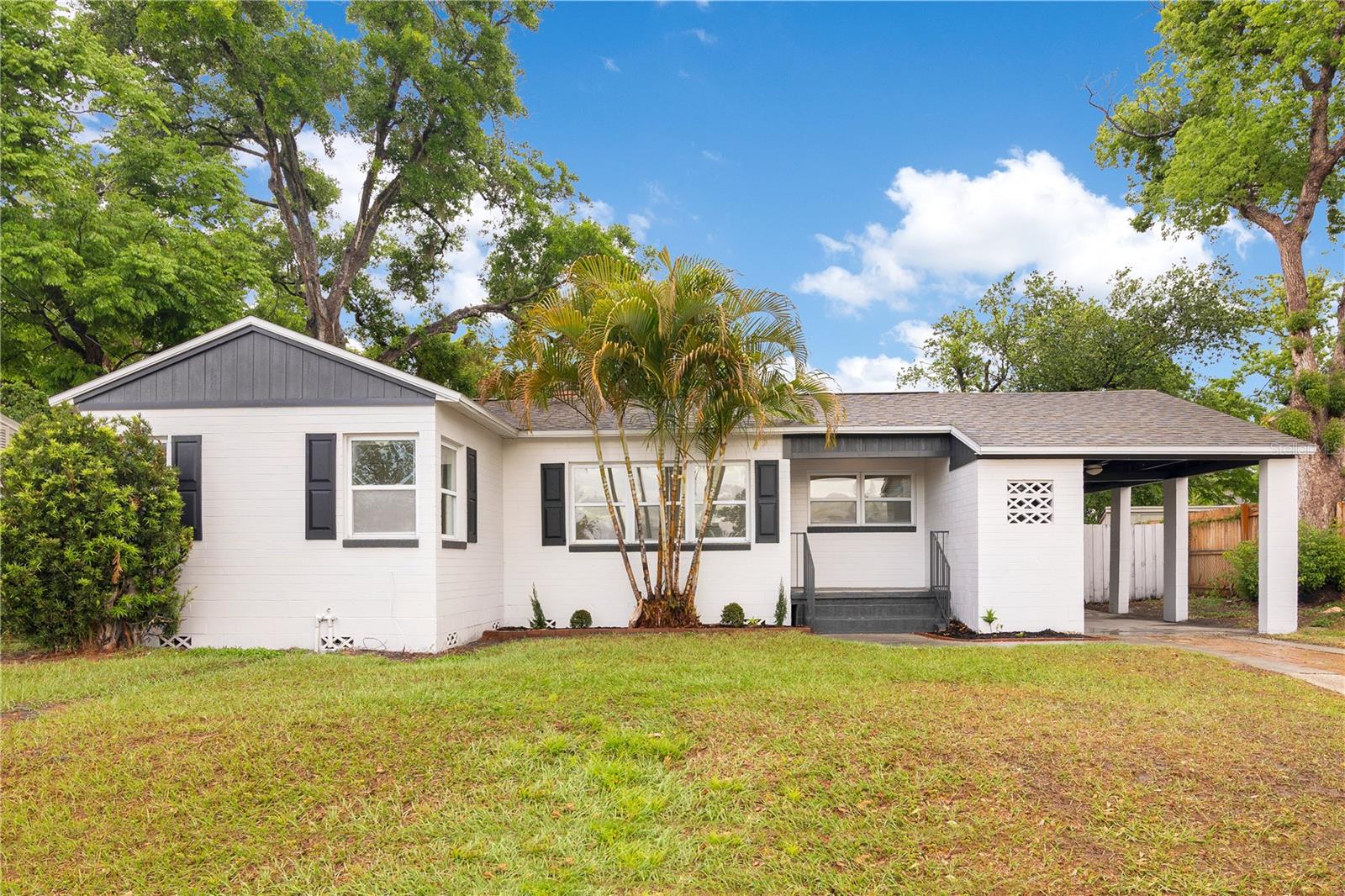 Freshly renovated and move-in ready, this updated 2-bedroom, 1-bath home delivers modern comfort with a stylish, low-maintenance design. Set on a generously sized lot with a freshly painted exterior, the home welcomes you with a clean new look, enhanced landscaping, and a covered carport with storage. Step inside to find all-new 20ML scratch-resistant laminate flooring, fresh interior paint, and an open living space filled with natural light. The kitchen has been completely remodeled with new cabinetry, countertops, and appliances, offering a functional layout with an easy flow to the main living spaces. Both bedrooms feature walk-in closets, and the bathroom has been fully renovated with a modern design, new tile, fixtures, and finishes. Behind the walls, the updates are just as extensive: new plumbing throughout, a brand-new water heater, and a full electrical overhaul, including grounding, rewiring, and two new panels. Out back, a new firepit area and mature shade trees create a great space for relaxing or entertaining, with a fully fenced yard offering added privacy. Conveniently located just minutes from downtown Orlando, the Packing District, and College Park, this home is ideal for anyone seeking a stylish, move-in-ready property!