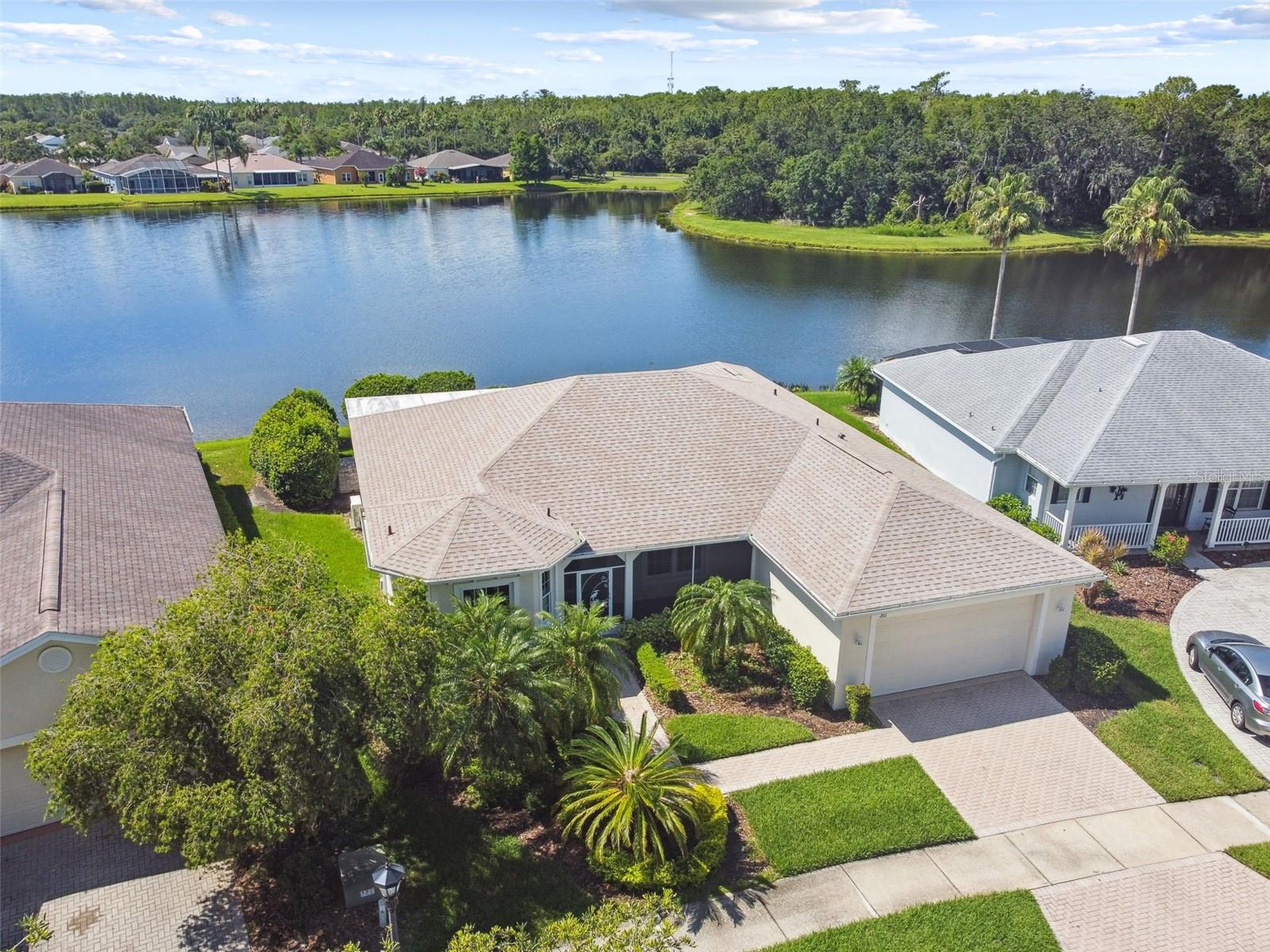 Discover serene Florida living in this beautifully upgraded Carnegie model nestled in a quiet, sought-after Solivita neighborhood—just minutes from the vibrant Village Center amenities. This 2-bedroom, 2-bathroom home, with additional 4 season room and Florida room, offers picturesque water views and a thoughtfully designed split floor plan for optimal privacy. Enter through a charming screened-in front porch into a spacious great room that showcases the stunning water view. The heart of the home is the chef’s gourmet kitchen, featuring an eat-at bar, custom 42" maple cabinetry, double built-in ovens, a cook top, and a kitchen island—perfect for entertaining and everyday living. Enjoy a Florida room and a versatile 4-season room with solar shades, ideal for year-round comfort. The cozy breakfast nook offers a relaxing space to start your day. The primary suite is a peaceful retreat with water views, dual walk-in closets, and a luxuriously remodeled en-suite bathroom (2022) with split vanities, a makeup area, and a custom shower with seating. The guest bedroom and bathroom are thoughtfully positioned on the opposite side of the home for added privacy. Step out to your screened and covered lanai, where you’ll find a private hot tub overlooking the tranquil water—a perfect place to unwind. This stress-free, move-in-ready home includes major recent upgrades: New Roof (2024), New HVAC (2022), High-efficiency windows (2022), New hot water heater (2023), Water softener (2022), Epoxy flooring in the extended 2-car garage (2023),  Exterior painted (2022),  and Extra insulation. CDD DEBT PAID OFF! Some furnishings and a 2023 golf cart are available outside of contract. Don’t miss this rare opportunity to own a meticulously maintained, upgraded home with stunning water views in one of Central Florida’s premier 55+ communities.  Solivita is renowned for its vibrant 55+ community, offering an array of activities and amenities tailored to active adults. Whether you’re enjoying a round of golf, engaging in fitness classes, or simply strolling along scenic walking paths, this neighborhood promotes an active and fulfilling lifestyle with over 200 clubs, sports, and activities to choose from. Enjoy the community’s clubhouse, softball field, 14 swimming pools, an indoor walking track, and much more. Every day offers something new to explore and enjoy! This home also features easy access to nearby shops, dining, and health care, offering the perfect balance of privacy and lifestyle.