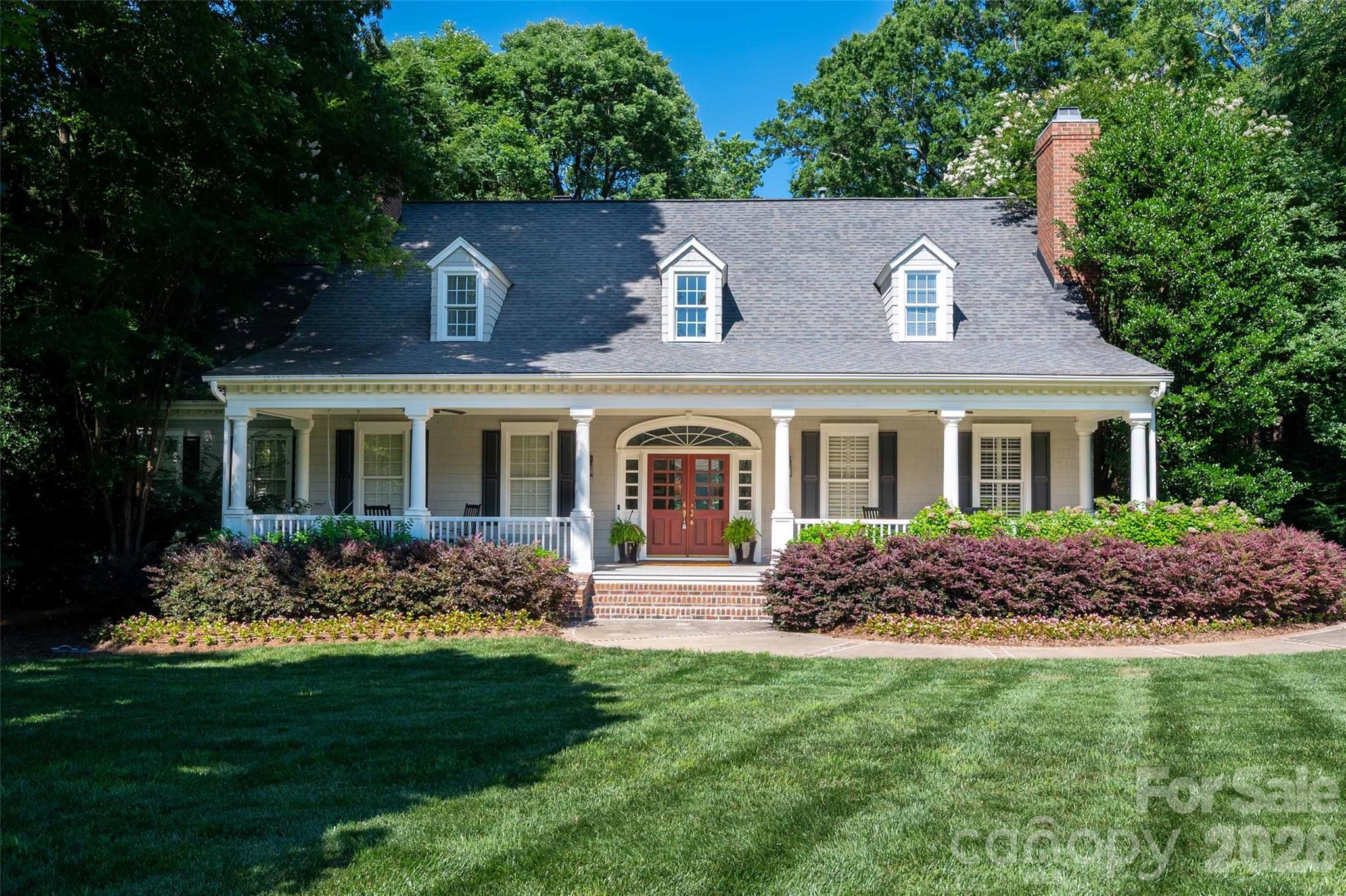 Southern charm meets Cape Cod chic in the highly sought-after, gated community of Providence Downs! This cedar-shake masterpiece greets you with an inviting covered front porch perfect for morning coffee and rocking chairs. Step through the double front doors into a grand 2 story foyer framing picturesque views straight through to the scenic backyard. The sun drenched main level boasts soaring 10-foot ceilings, elegant plantation shutters, and gorgeous wide-plank heart of pine floors. The bright, welcoming kitchen centers around a functional island and features crisp white cabinetry, premium stainless appliances, and timeless Carrera marble countertops. Cozy up by any of the home's FOUR stately fireplaces, including one in the primary bedroom situated conveniently on the main floor. Upstairs features three generous secondary bedrooms and a spacious bonus room overflowing with possibilities. True hospitality transitions effortlessly outdoors to a magnificent tiered deck—your front-row seat to peaceful views of the neighborhood pond and water feature. Enjoy a resort-style lifestyle with a neighborhood pool, clubhouse, tennis courts, playground, and walking trails, all while zoned for TOP RATED MARVIN RIDGE SCHOOLS!  Conveniently located to Blakeney and Waverly shops and restaurants.