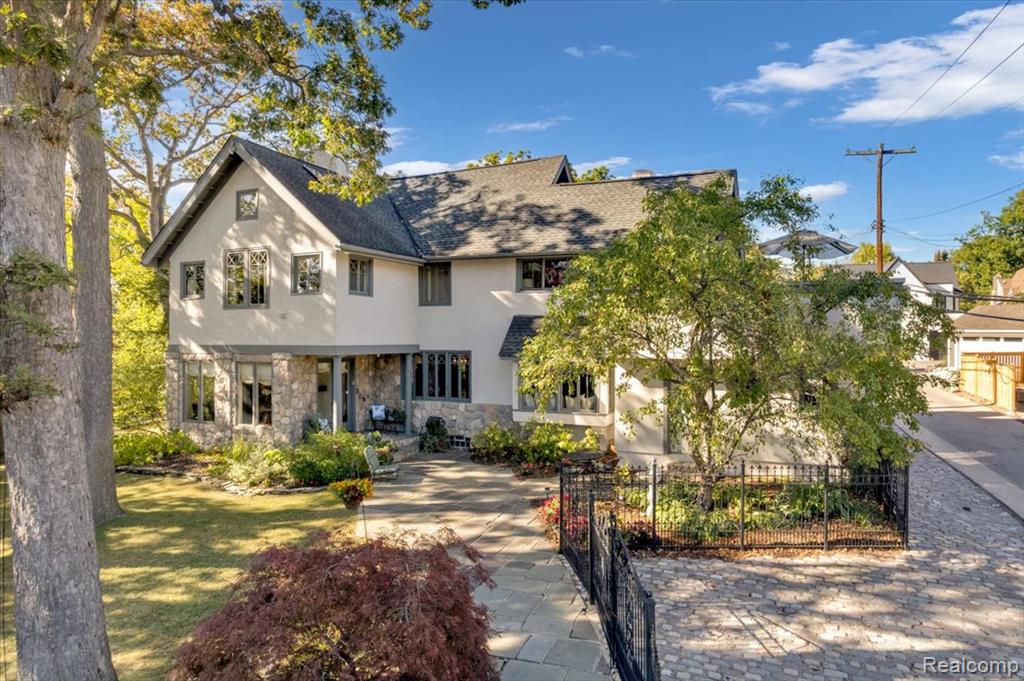 Nestled in the heart of the desirable Little San Francisco neighborhood in Birmingham, this charming Arts and Crafts style home offers unparalleled privacy and serenity on a spacious double lot. Just steps from downtown Birmingham, with Quarton Lake, Booth Park, and an array of restaurants and shops nearby, it combines urban convenience with a tranquil retreat.The exterior boasts a stunning stucco, stone, and wood trim elevation, enveloped by a black iron fence and stone and block wall that fully encloses the property for ultimate privacy. Lush landscaping features many mature trees, including seven majestic oaks, and a peaceful koi pond with a waterfall, that enhances the outdoor oasis. Ample parking includes a 2-car, attached garage, plus a dedicated parking pad for up to five additional vehicles.Inside, the home exudes timeless elegance with new hardwood floors throughout the first floor and an abundance of large windows, many with decorative accents, including some original designs, all upgraded to energy-efficient double-pane glass for natural light and views. The newly updated executive chef's kitchen is a culinary dream, equipped with a premium Wolf stove/oven and Sub-Zero built-in refrigerator.  This beautiful kitchen also opens to a walled courtyard perfect for al fresco dining or morning coffee.Upstairs, discover four charming bedrooms, including a luxurious master suite with an extra-large master bath featuring cathedral ceilings, a jetted tub and walk-in shower. Convenience abounds with second-floor laundry, while three cozy fireplaces add warmth and ambiance throughout the home.Elevate your lifestyle with the unique second-floor wrap-around deck above the garage, offering breathtaking views in all four directions, ideal for entertaining or simply unwinding. This property is a rare gem, blending classic craftsmanship with modern updates in one of Birmingham's most sought-after locales.