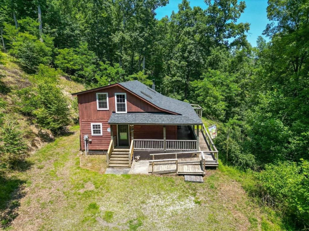 Private mountain retreat bordering Crooked Creek! This rustic cabin features 3 bedrooms and 2 full baths with over 1,400 square feet of living space. Has a spacious open floor plan with double stone fireplace, refinished hardwood and laminate flooring. Many recent updates have been completed including a new roof, well pump, chimney liner and cap. Kitchen has new wiring, cabinets, granite countertops, and tankless water heater. New baseboard electric in bedrooms and dining room.  Custom tile shower on main level and newer vanity in upstairs bath with new faucet and countertop. Private wooded setting with 2 storage buildings and firepit area. Situated on 3.64 acres, this property is close to the Crooked Creek Wildlife Management area and the scenic Blue Ridge Parkway. Also conveniently located within 10 minutes of I-77 and US 52 for easy commute making this an excellent weekend or recreational retreat!