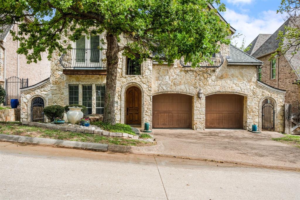 Tucked inside a private gated enclave in the heart of Trophy Club, this stunning stone-front residence offers the rare combination of luxury, community, and unbeatable location. From the moment you arrive, the European-inspired limestone exterior, dual Juliet balconies, and arched hardwood entry door set the tone for what's inside. Soaring vaulted ceilings with exposed wood beams, rich hardwood floors throughout, and a floor-to-ceiling stone fireplace anchor the open living space with warmth and character. The chef's kitchen impresses with custom cabinetry, dark granite countertops, stainless double ovens, a built-in microwave, and an oversized wraparound island with seating for the whole crew. A formal dining room with wainscoting, a built-in desk nook, and covered back patio with ceiling fans round out a home designed for both everyday living and effortless entertaining.The backyard is private, landscaped, and ready for your vision. But the real story here is where you're sitting. Steps from your front door, grab a bite at HG Supply or explore the growing Trophy Club dining scene. The Westlake financial drive is just minutes away.  Dallas and Ft Worth are easily accessible, too. Heading to Southlake Town Square for shopping, dining, or a movie? You're barely 10 minutes away. And DFW International Airport? Less than 20 minutes — a serious win for frequent travelers or anyone with family flying in. This lock-and-leave luxe villa is one of DFW's most coveted suburban pockets — where neighborhood charm meets metropolitan convenience. Welcome to the good life at 4 Hanna Court.